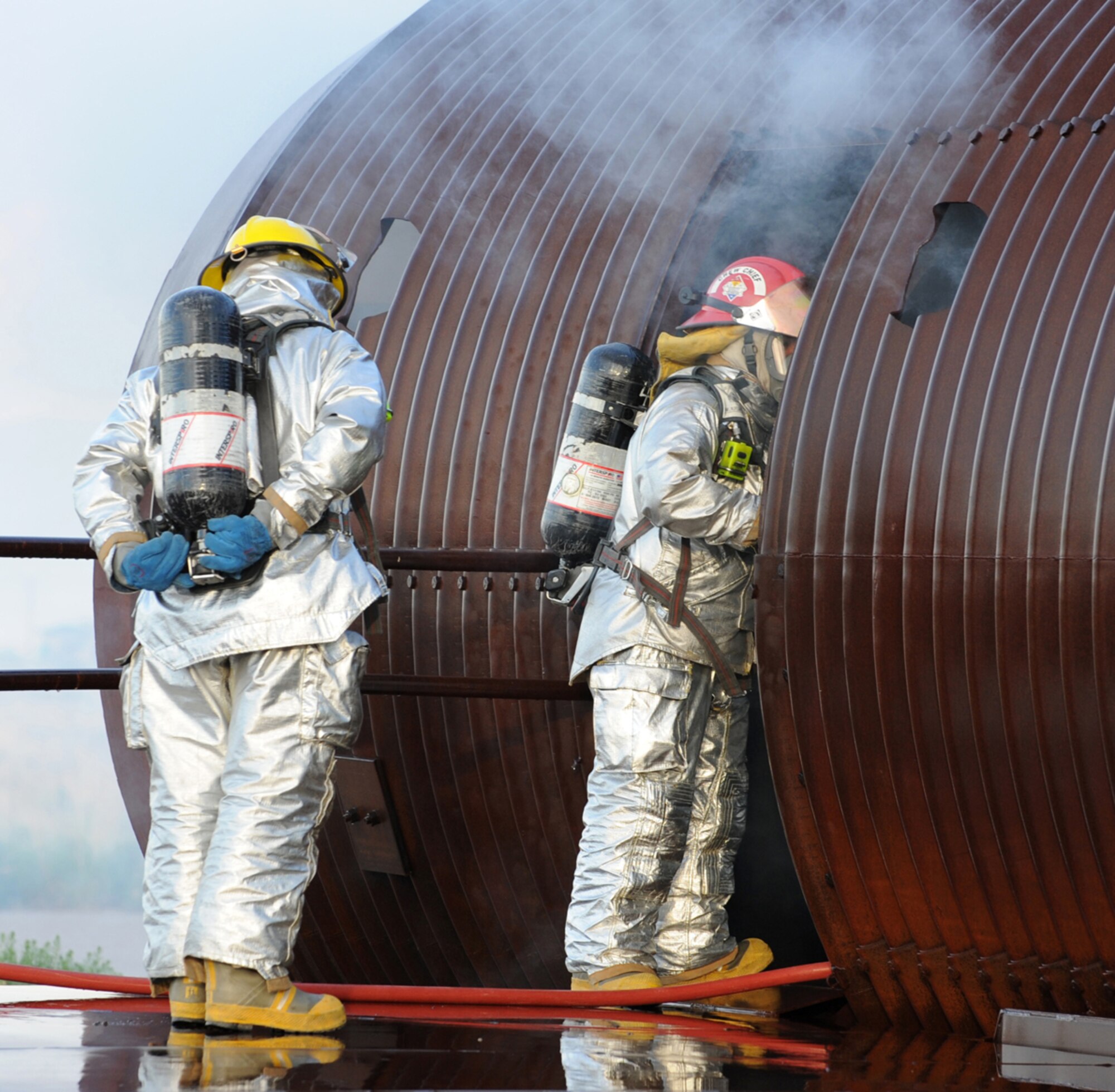 HOLLOMAN AIR FORCE BASE, N.M. -- Two members of the initial entry team begin their rescue and prepare to put out any additional fires in a simulated C-17 Globemaster III during the Major Accident Response Exercise here July 23. The Fire Emergency Services personnel were responding to a simulated C-17 crash at the fire training pit here, where an artificial aircraft is permanently set up for training purposes. Meanwhile, an emergency operations center stood up to provide command and control of the situation. (U.S. Air Force photo by Airman 1st Class Sondra M. Escutia)