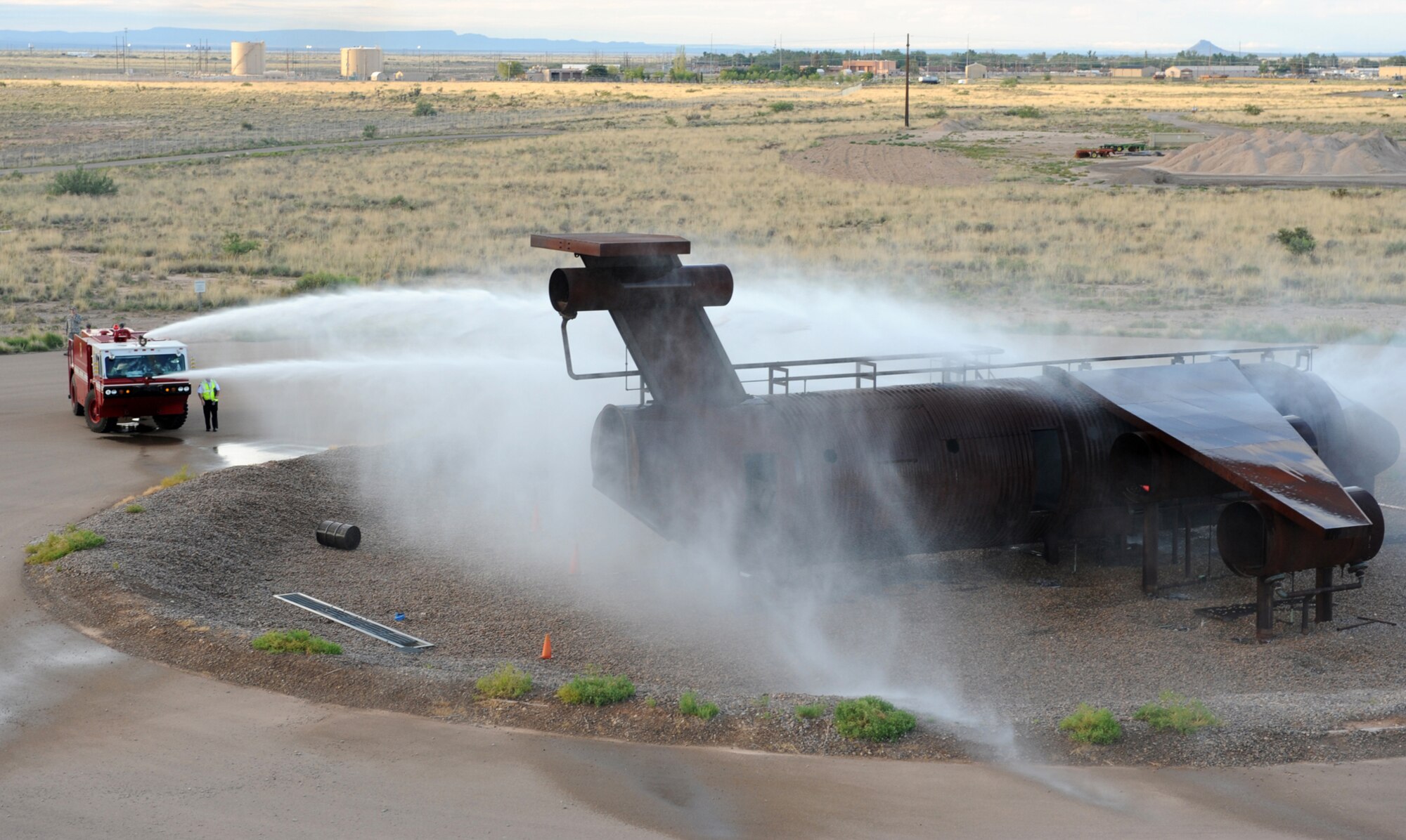 HOLLOMAN AIR FORCE BASE, N.M. -- Fire Emergency Services douse the fire on a simulated C-17 Globemaster III upon initial arrival to the crash scene during the Major Accident Response Exercise here July 23. In the exercise scenario, the C-17 declared an in-flight emergency after two engines were damaged in a hailstorm. It crashed short of a runway at Holloman and caught fire. The aircraft was carrying seven personnel and a simulated weapon. (U.S. Air Force photo by Airman 1st Class Sondra M. Escutia)