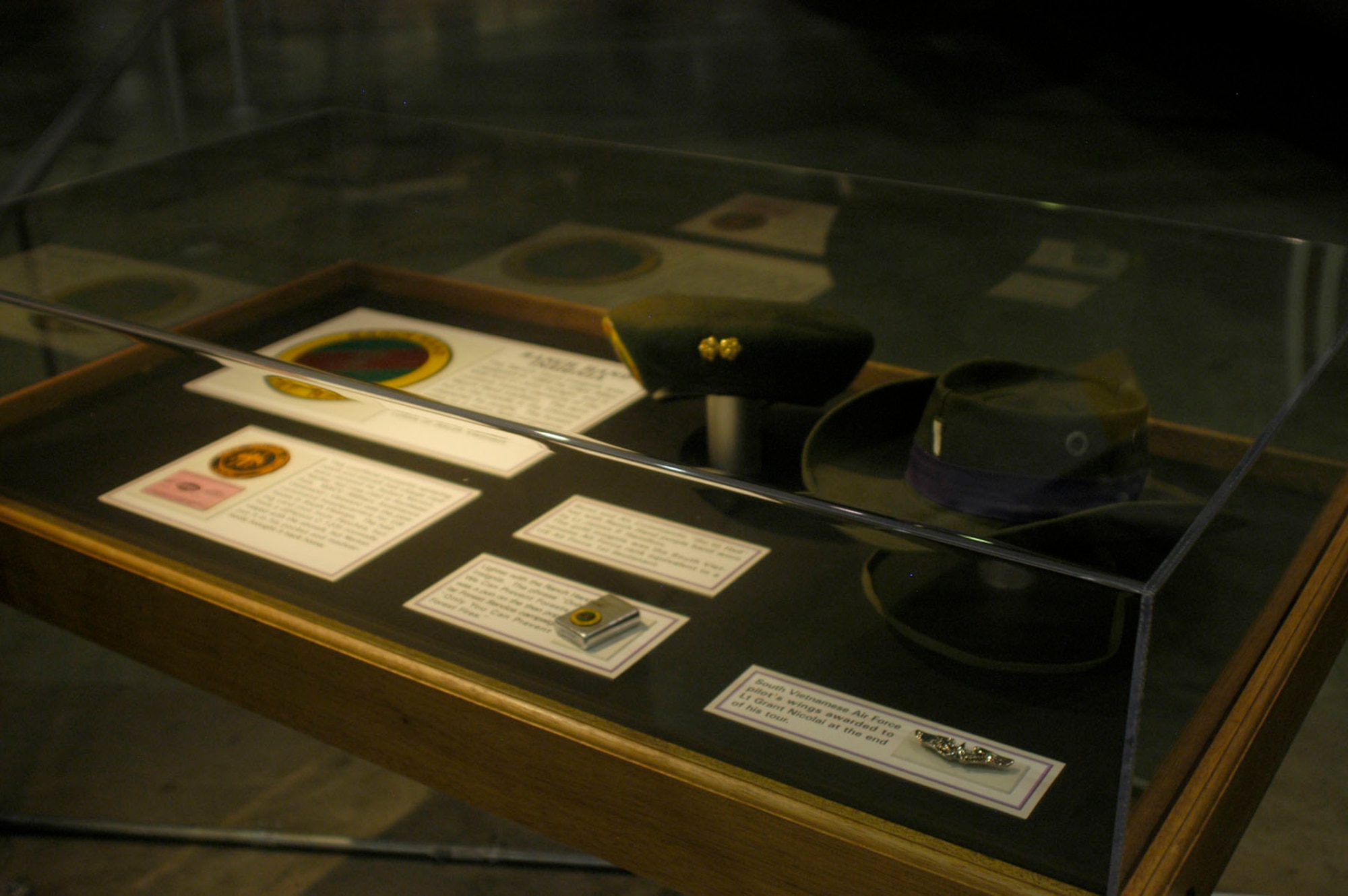 DAYTON, Ohio - Insignia, patch, lighter, hats and pilot's wings on display in part of the Down in the Weeds: Ranch Hand exhibit in the Southeast Asia War Gallery at the National Museum of the U.S. Air Force. (U.S. Air Force photo)