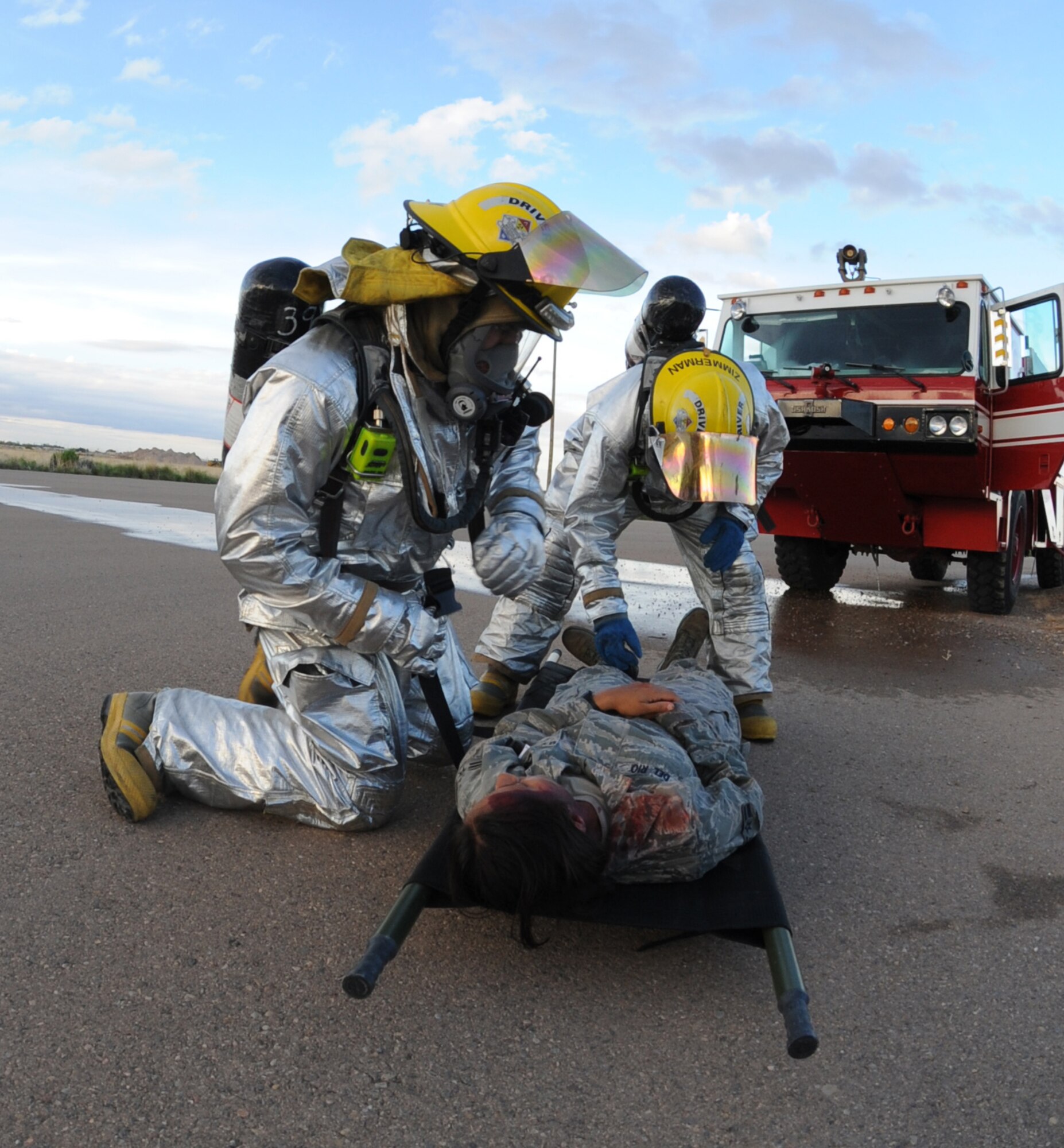 HOLLOMAN AIR FORCE BASE, N.M. -- Holloman Fire Emergency Services personnel strap a simulated victim to a litter to prepare her for transportation during the Major Accident Response Exercise here July 23. The victims were taken through a simulated decontamination line and then to medical for further care, while the Explosive Ordinance Disposal team assessed the aircraft. (U.S. Air Force photo by Airman 1st Class Sondra M. Escutia)