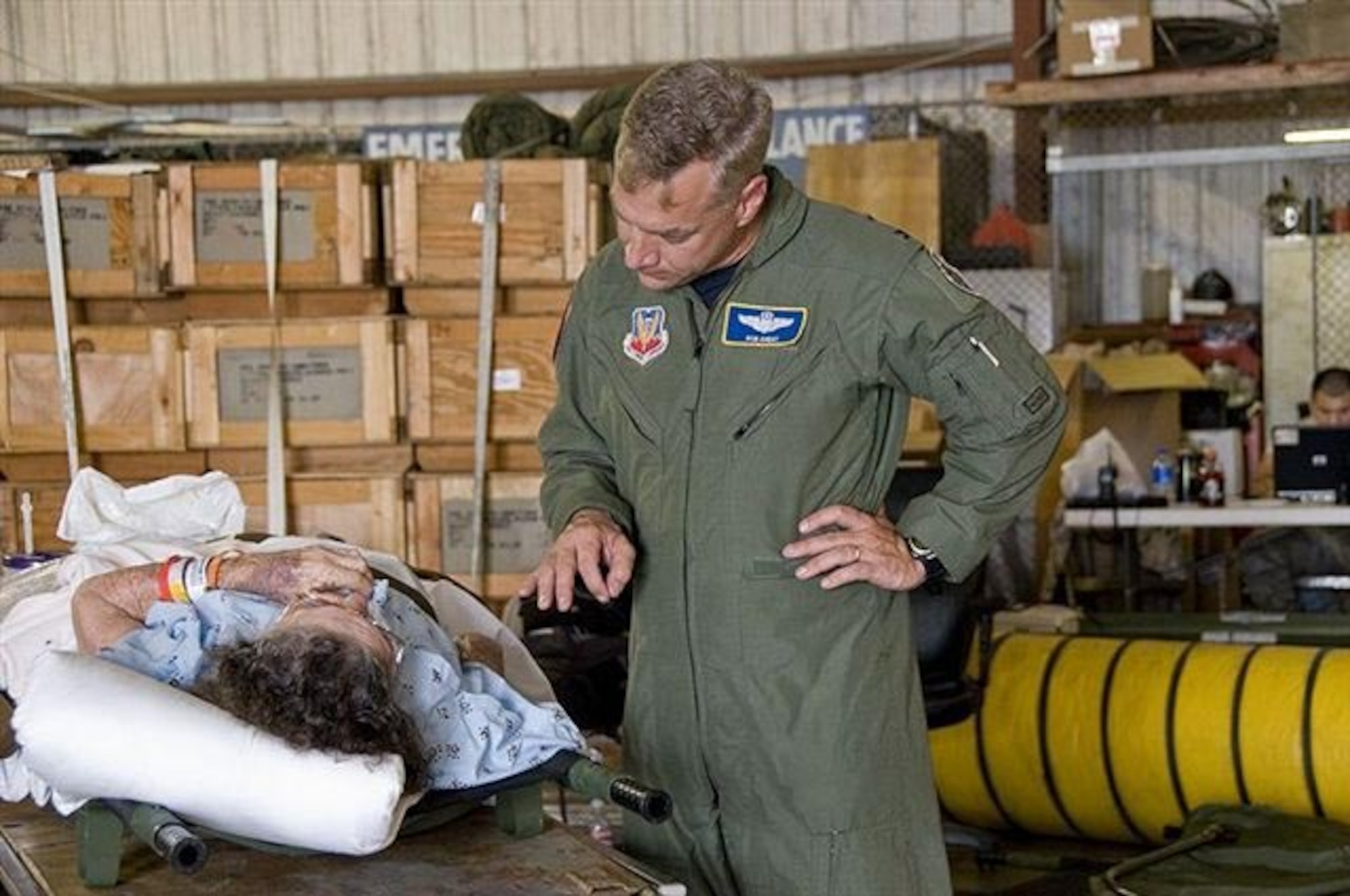 Col. Rob Ament comforts a critically ill patient evacuated from a coastal Texas hospital during Hurricane Ike in 2008.   The Emergency Preparedness Liaison Officer assisted with evacuations by helping carry more than 100 patients onto an Air Force C-130, where they were flown to safer inland locations. (U.S. Federal Emergency Management Agency photo by Patsy Lynch)