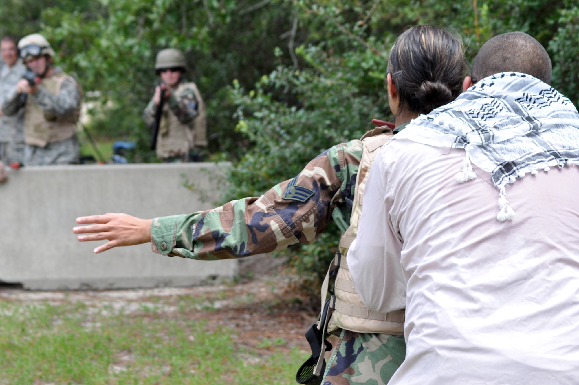 EGLIN AIR FORCE BASE, Fla. – Esteban Ruiz, 96th Security Forces Squadron Combat Skills Training instructor, simulates a hostage situation while training Airmen in a defense fighting position during CST here, July 28. CST is a course that covers everything from use of deadly force to salute reporting and is required for most members as a refresher to prepare them for situations they may encounter in theatre. (U.S. Air Force photo/ Airman Anthony Jennings)