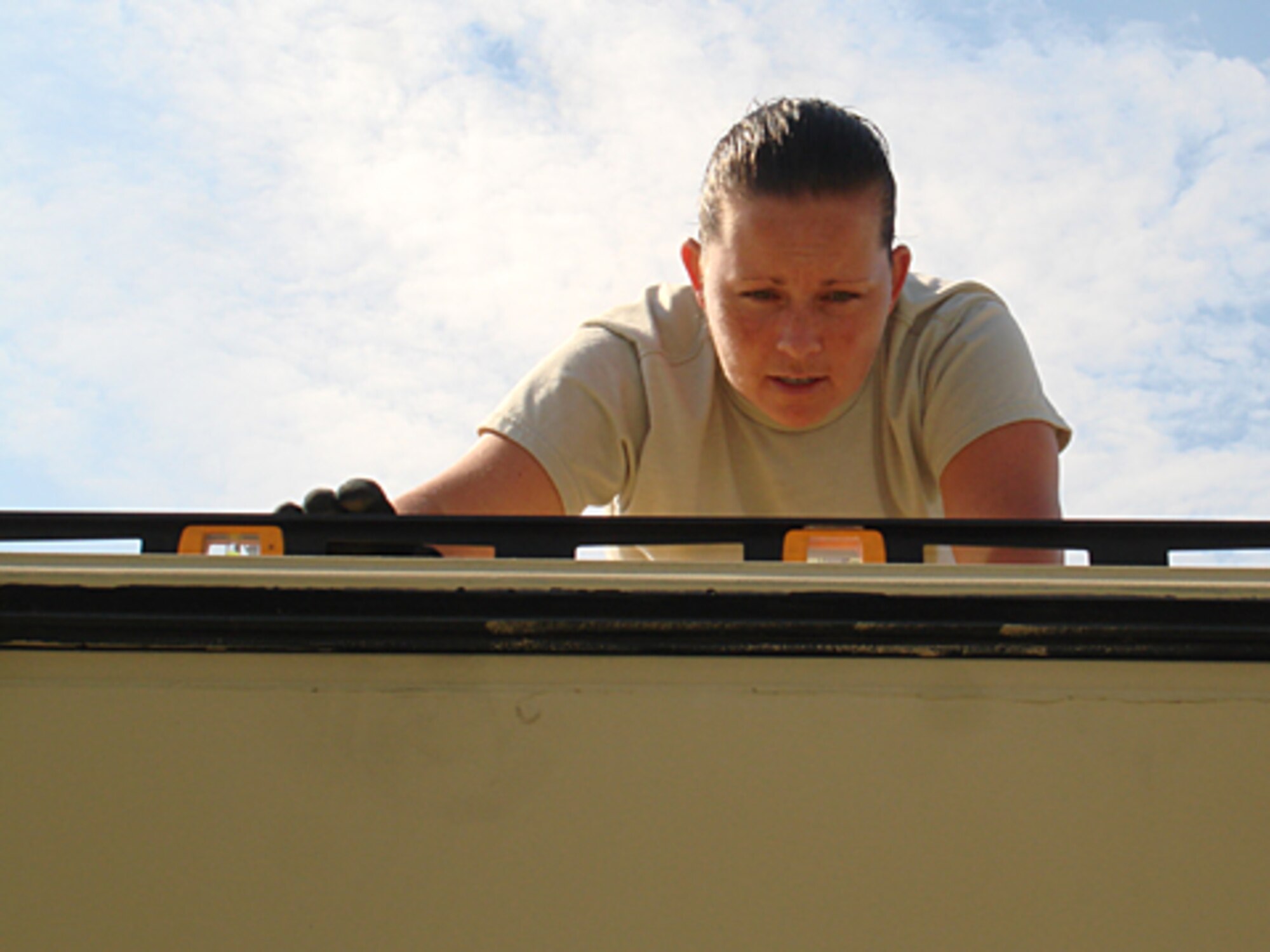 Tech. Sgt. Asilynn Monroe, 21st Air Mobility Operations Squadron, levels  the three- in-one expeditionary shelter during the 2009 internal flex exercise July 20 at Global Reach Deployment Center compound. The exercise provided a venue to link the three missions of the AMOS: Air Mobility Division, Expeditionary Communications and Expeditionary Facilities. (U.S. Air Force photo/Staff Sgt. Frank Lalic)
