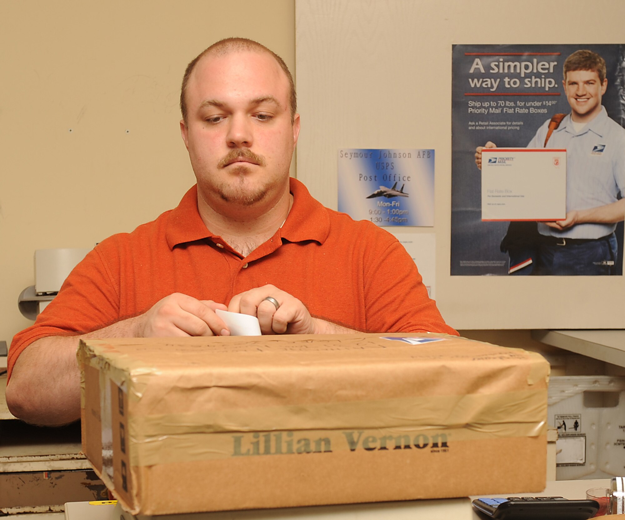 David Medus, U.S. Postal Service clerk, places a shipment stamp on a package on Seymour Johnson Air Force Base, N.C., July 24, 2009. If a package or letter is placed in the mail without the proper amount of stamps it will be returned to sender, this rarely occurs. (U.S. Air Force photo by Airman 1st Class Whitney S. Lambert)