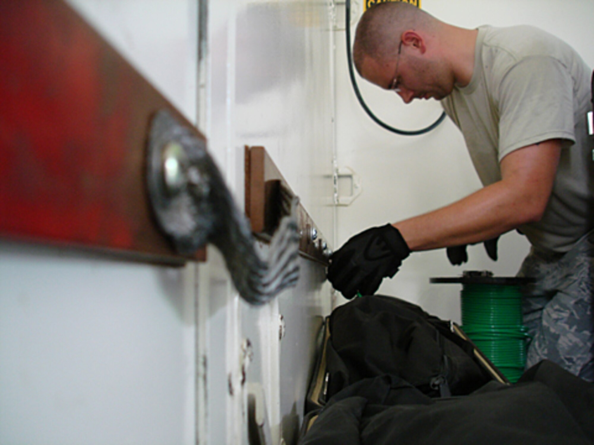 Staff Sgt. Matthew Cann, 21st Air Mobility Operations Squadron, connects a wire to a ground rod during the 2009 internal flex exercise July 20 at the Global Readiness Deployment Center compound. The exercise was designed to prepare the squadron for its upcoming deployment to Ulchi Freedom Guardian 2009 in Korea.(U.S. Air Force photo/Staff Sgt. Frank Lalic)