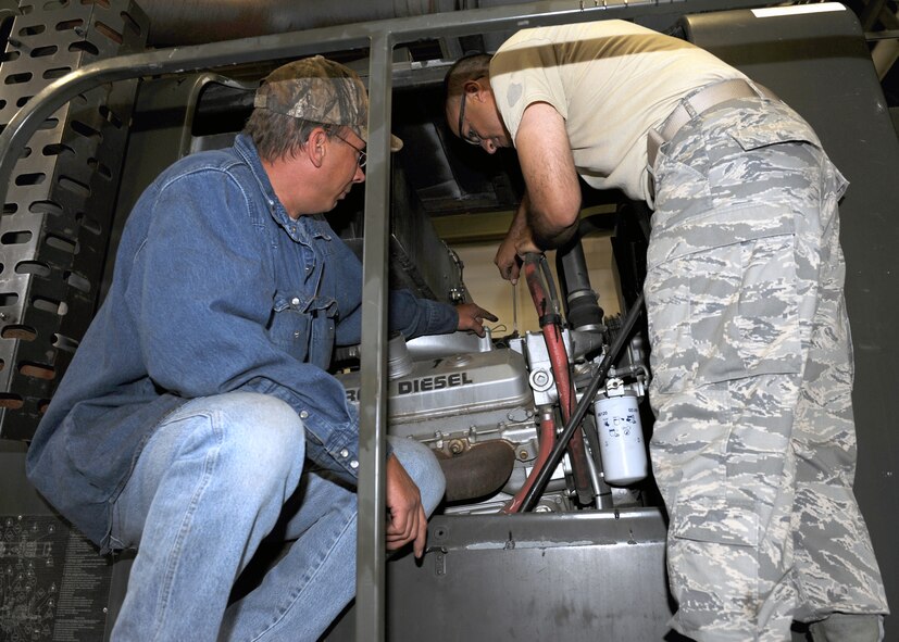 MINOT AIR FORCE BASE, N.D. -- Mr. Larry Giese, a heavy equipment mechanic for the 5th Logistics Readiness Squadron, assists Staff Sgt. Dennis Delgado-Demenech, non-commissioned officer in charge of summer rebuild (5th Logistics Readiness Squadron), repair an engine on one of the base’s snow plows, here Jul 29. The plows are vital to the base continuing their mission during the coldest days of the winter, by clearing the streets of snow. (U.S. Air Force photo by Staff Sgt. Keith Ballard)
