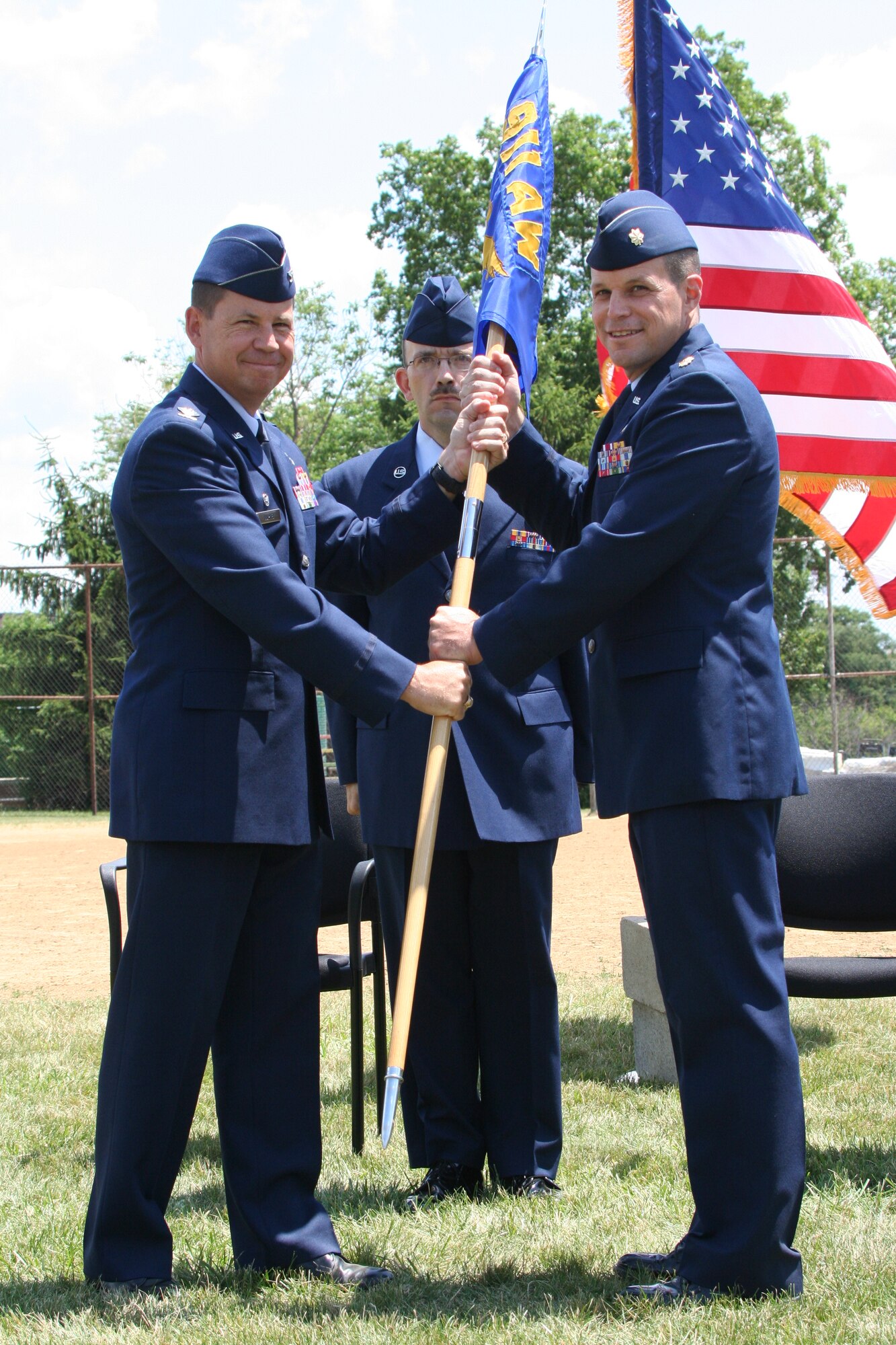 Maj. Lowell “Buzz” Bingham receives the Military Personnel Flight guidon from Col. James P. Hurley, Mission Support Group commander during a change of command ceremony held here July 12, 2009 (photo by Master Sgt. Mark Winklosky.)