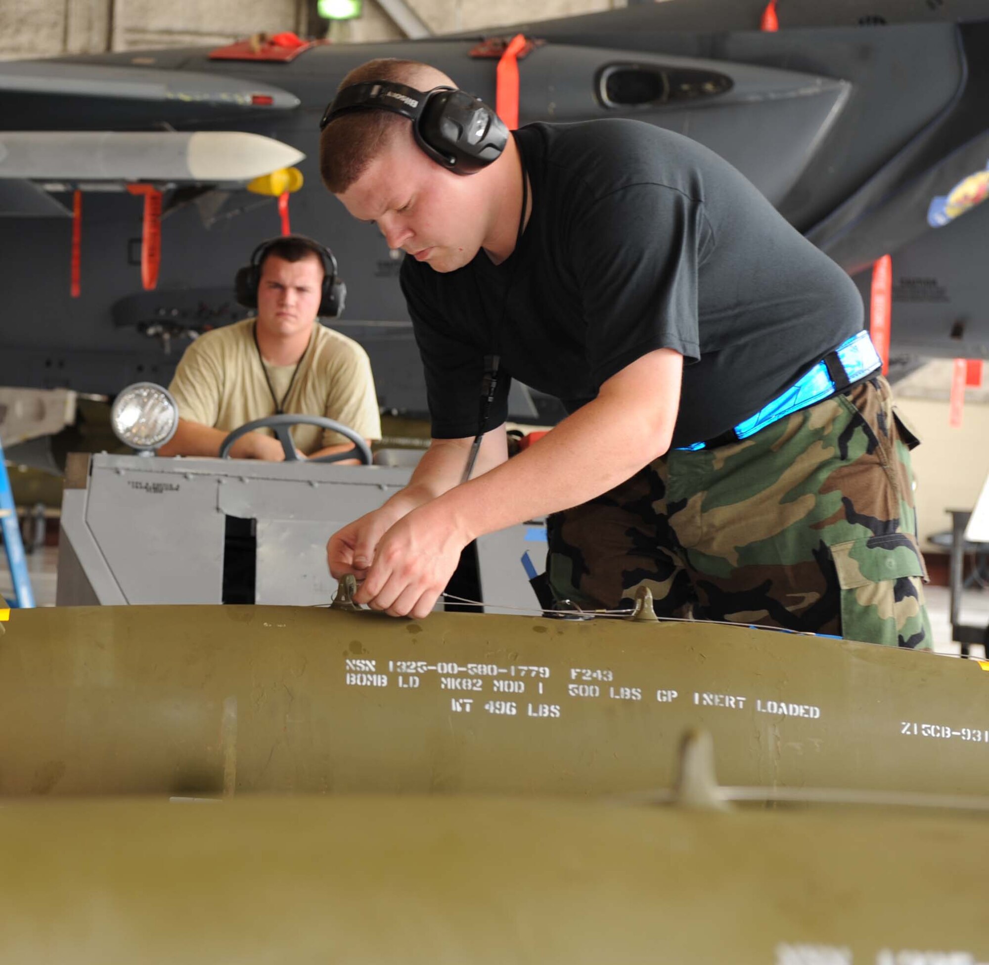 Staff Sgt.  Thomas Cunningham and Airman 1st Class Thomas Williams, 334th Aircraft Maintenance Unit weapon loaders, prepare a practice bomb for loading during the load crew competition at Seymour Johnson Air Force Base, N.C., July 17, 2009. The best load crews from each aircraft maintenance unit were selected to compete for the title of best load crew on base. (U.S. Air Force photo by Airman 1st Class Gino Reyes)