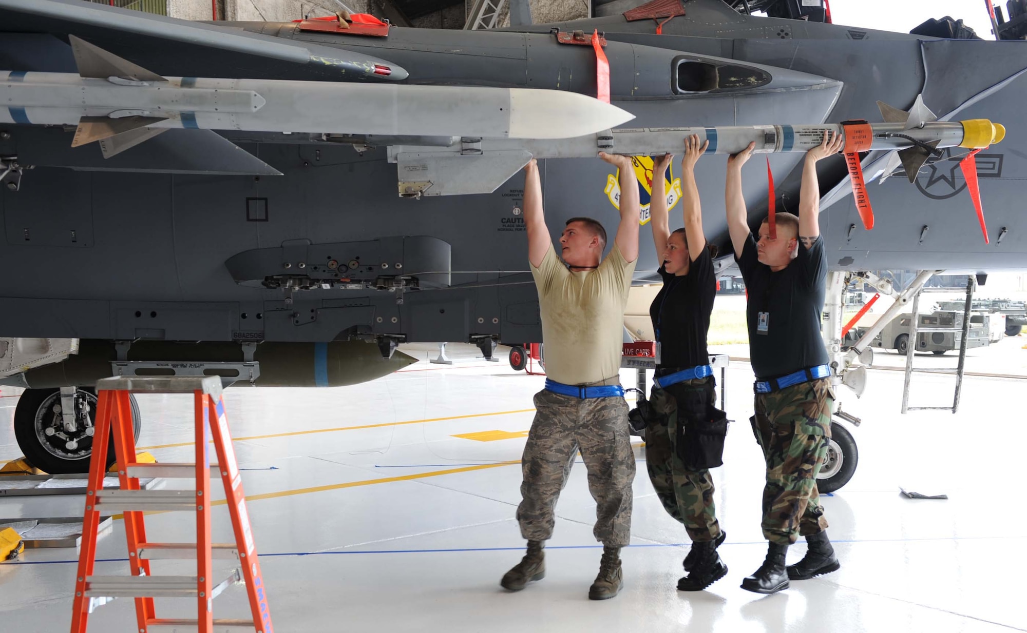 334th Aircraft Maintenance Unit load crew members, attach an Aim 9 practice missile to an F-15E Strike Eagle during a load crew competition at Seymour Johnson Air Force Base, N.C., July 17, 2009. An F-15E can carry up to four Aim 9 missiles at one time. (U.S. Air Force photo by Airman 1st Class Gino Reyes)