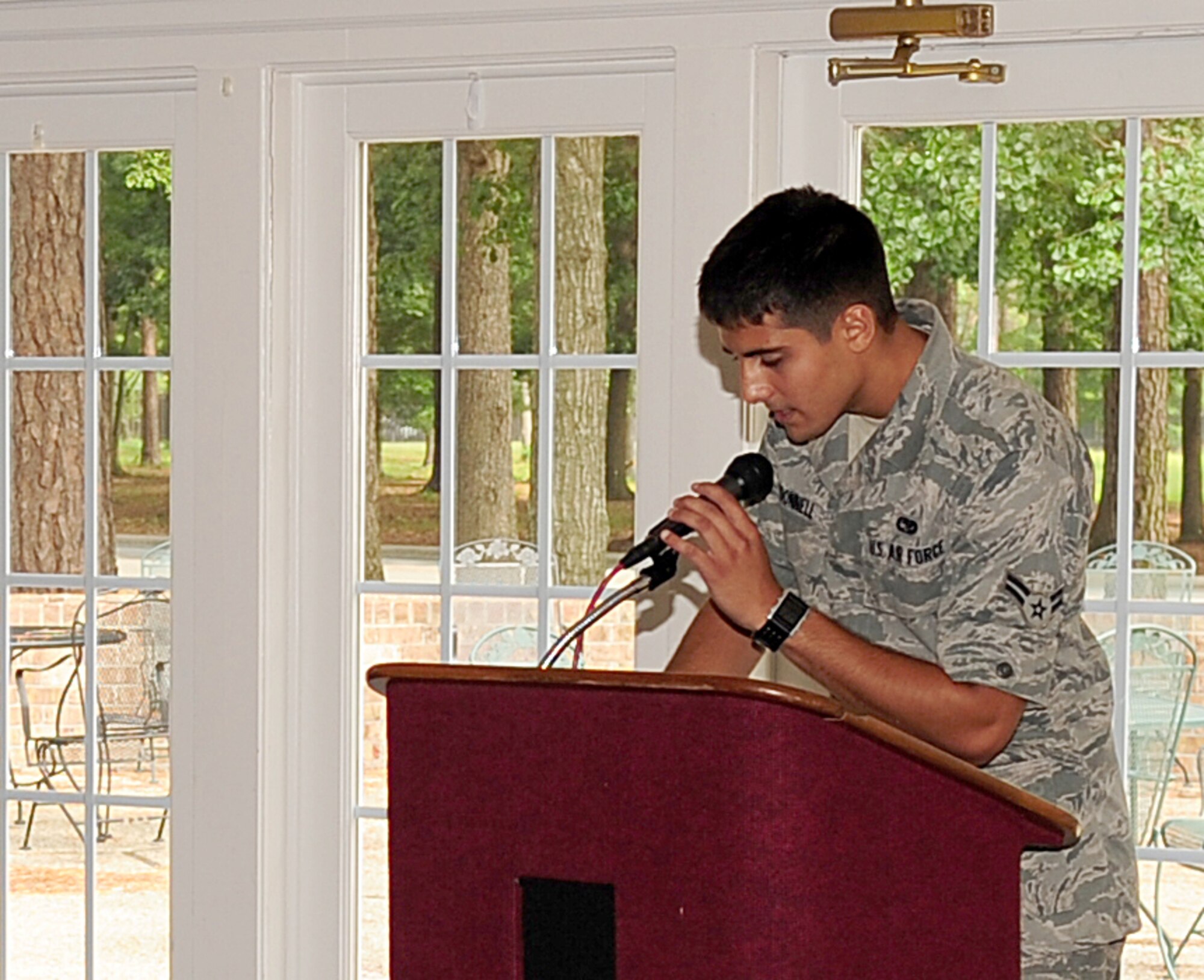 Airman 1st Class Ross O'Donnell, 4th Communications Squadron ground radio apprentice, speaks into a microphone while his partner adjusts the volume level in preparation for a retirement at Seymour Johnson Air Force Base, N.C. July 17, 2009. The sound levels are checked once the equipment is set up and again before the ceremony to ensure the volume is at an acceptable decibel level. (U.S. Air Force photo by Airman 1st Class Rae Perry)