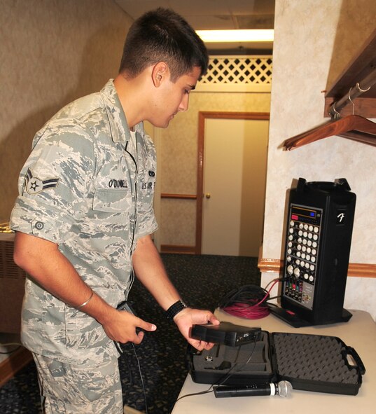 Airman 1st Class Ross O'Donnell, 4th Communications Squadron ground radio apprentice, sets up a wireless microphone for a retirement at Seymour Johnson Air Force Base, N.C., July 17, 2009. Airman O'Donnell recently graduated after five months of technical school training at Keesler Air Force Base, MS. (U.S. Air Force photo by Airman 1st Class Rae Perry)