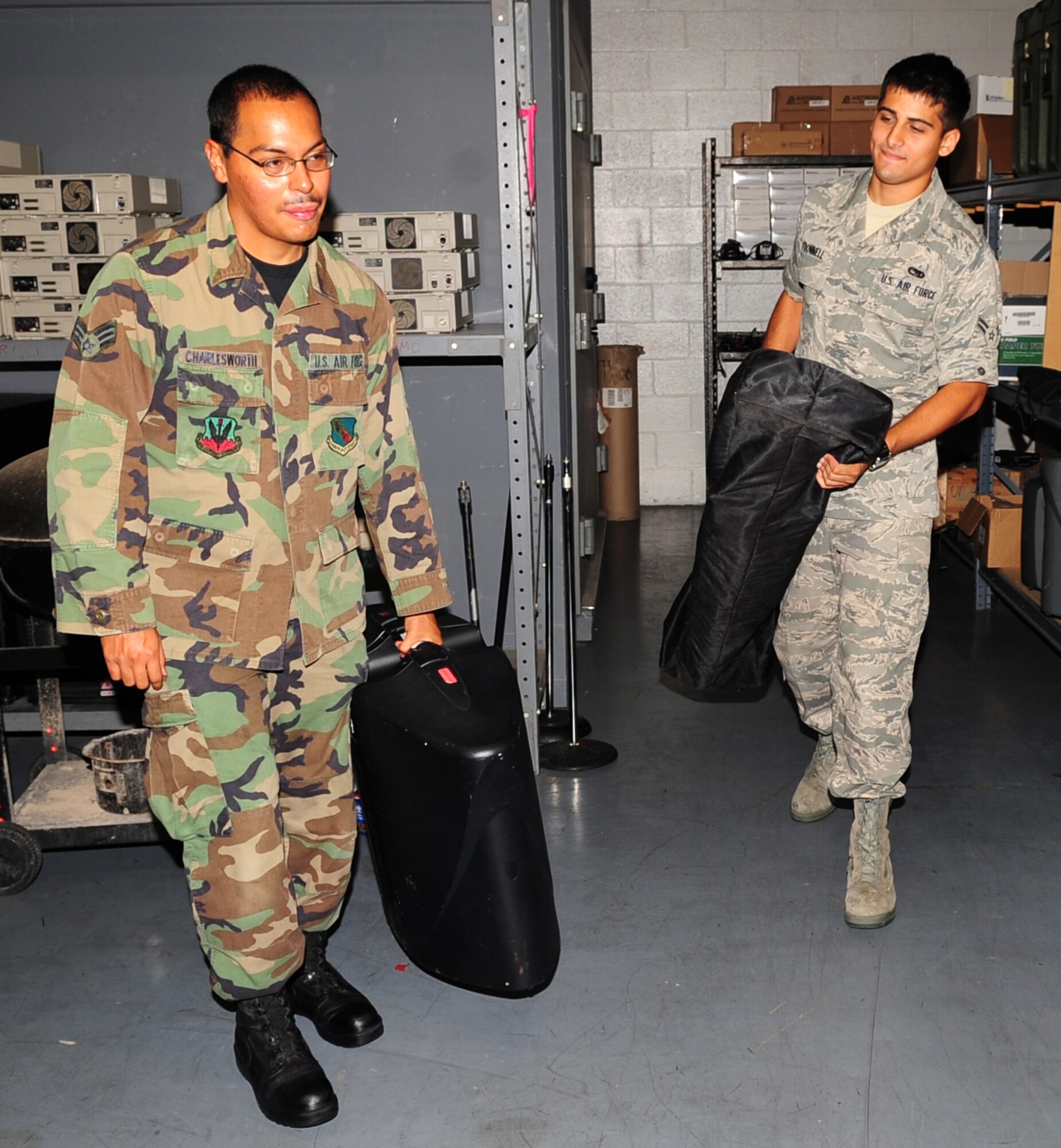 Senior Airman Jose Charlesworth and Airman 1st Class Ross O'Donnell, 4th Communications Squadron ground radio personnel, gather equipment needed for a retirement on Seymour Johnson Air Force Base, N.C., July 17, 2009. The men and women in the ground radio unit provide sound systems for more than 500 events a year ranging from all calls to retirements. (U.S. Air Force photo by Airman 1st Class Rae Perry)