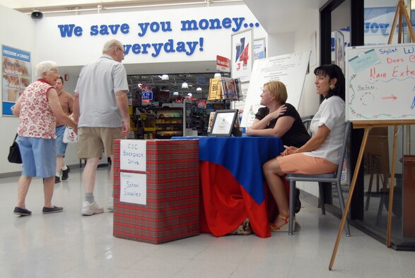 Alessandra Soltis (right) and Amanda Buffell (second from right), Enlisted Spouses Club members, talk to Base Exchange shoppers regarding the club's "Backpack Drive" July 28. The Edwards ESC partnered with the First Sergeants’ Council to collect school supplies for the students. (U.S. Air Force photo/Senior Airman Julius Delos Reyes)