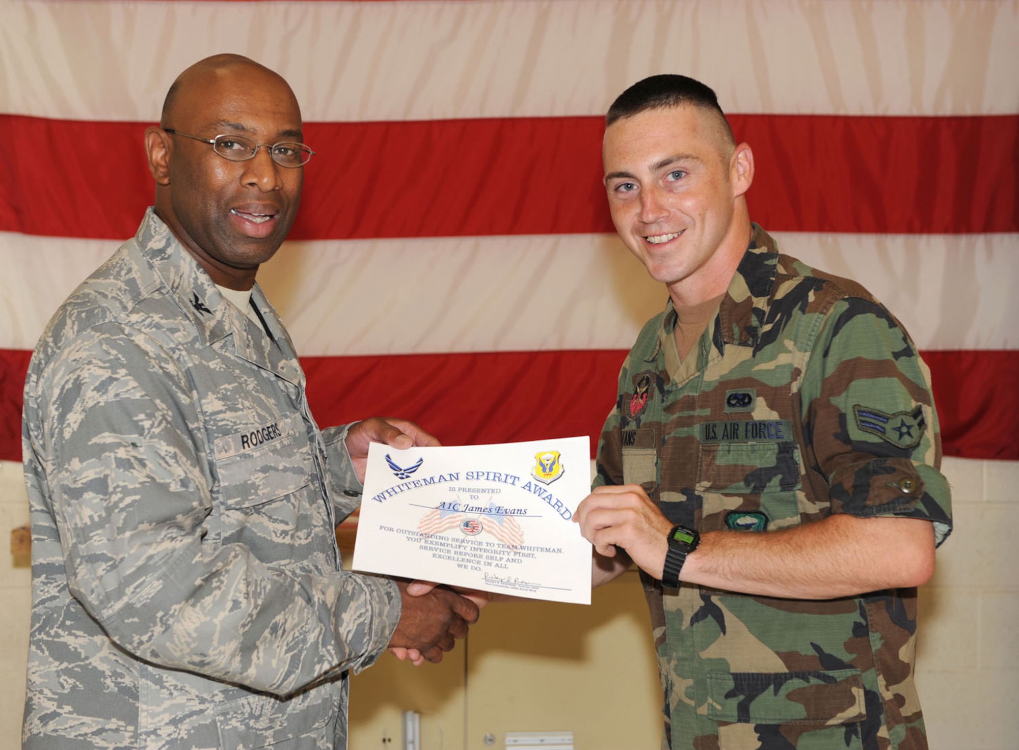 WHITEMAN AIR FORCE BASE, Mo. - Col. Rickey Rodgers, 509th Bomb Wing Vice Commander, presents Airman 1st Class James Evans with a Whiteman Spirit Award for ‘Service Before Self’. Airman Evans was nominated by Lt. Col Edwin Redman, 509th Bomb Wing Deputy Commander. (U.S. Air Forec photo/Airman 1st Class Carlin Leslie)