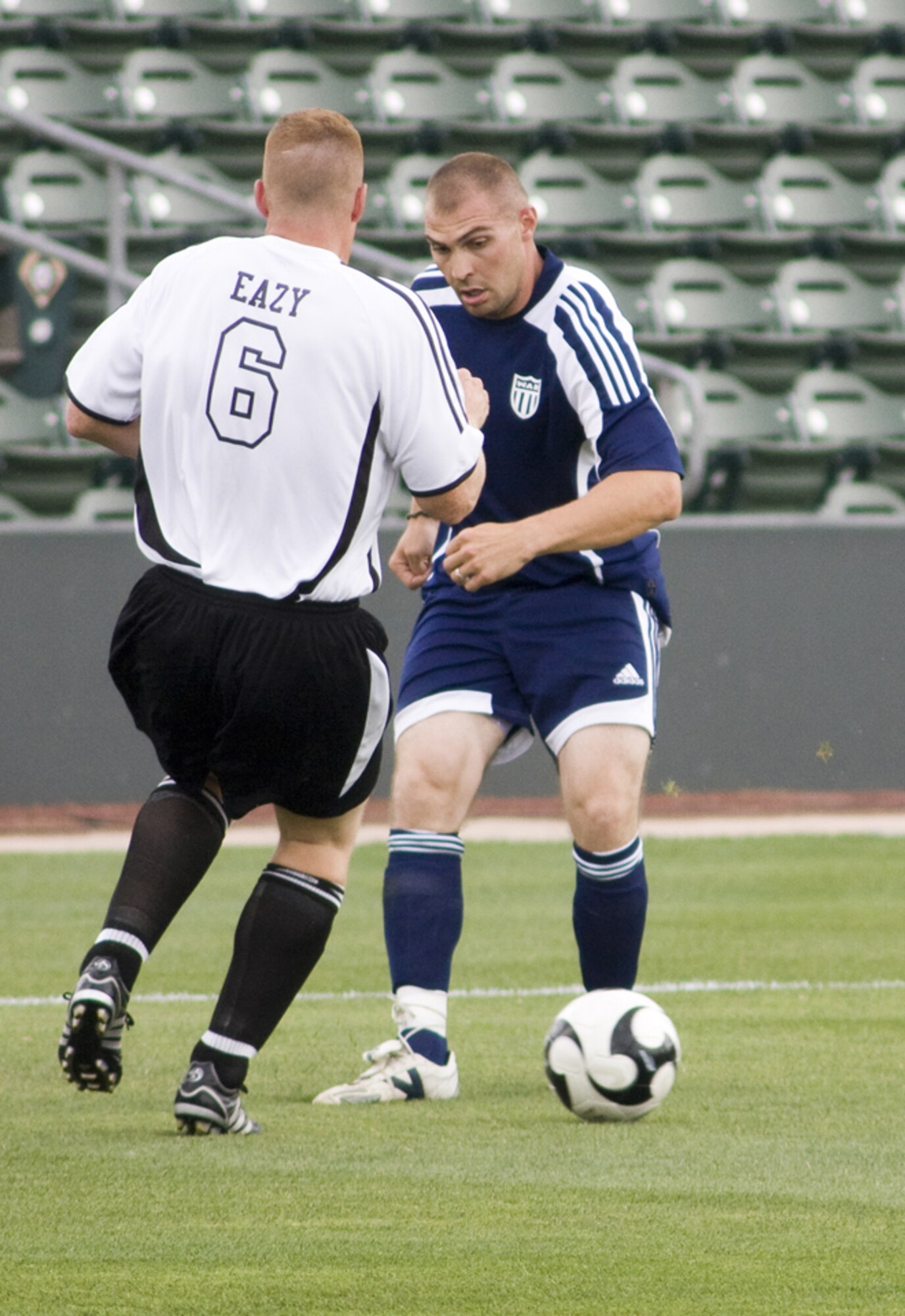 KANSAS CITY, Mo. – A member of Whiteman’s Varsity Soccer Team (blue jersey) attempts to move around his opponent July 4 during a game against the Marine Varsity Team from Richards-Gebaur Memorial Airport. Whiteman topped Richards-Gebaur with a score of 11-2. (U.S. Air Force photo/Capt. Allen Clark)