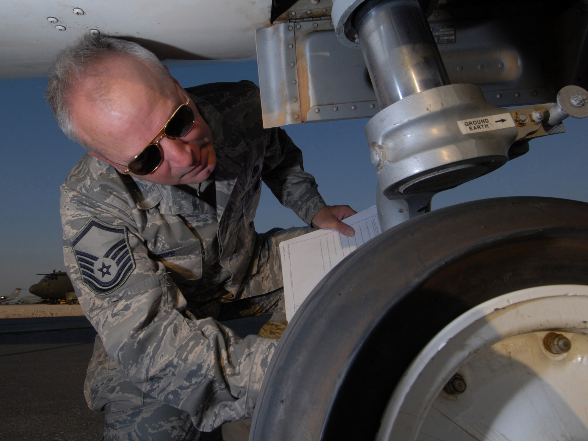 Master Sgt. Clinton Lowe, 379th Expeditionary Maintenance Group quality assurance inspector, inspects the nose gear strut on a C-21A here, July 29. Sergeant Lowe inspects maintenance processes, at all levels, and serves daily as a technical advisor to the maintenance leadership. He is a native of Fargo, N.D., and is deployed from Hector International Airport, North Dakota Air National Guard, in support of Operations Iraqi and Enduring Freedom.  (U.S. Air Force Photo/Tech. Sgt. Jason W. Edwards)