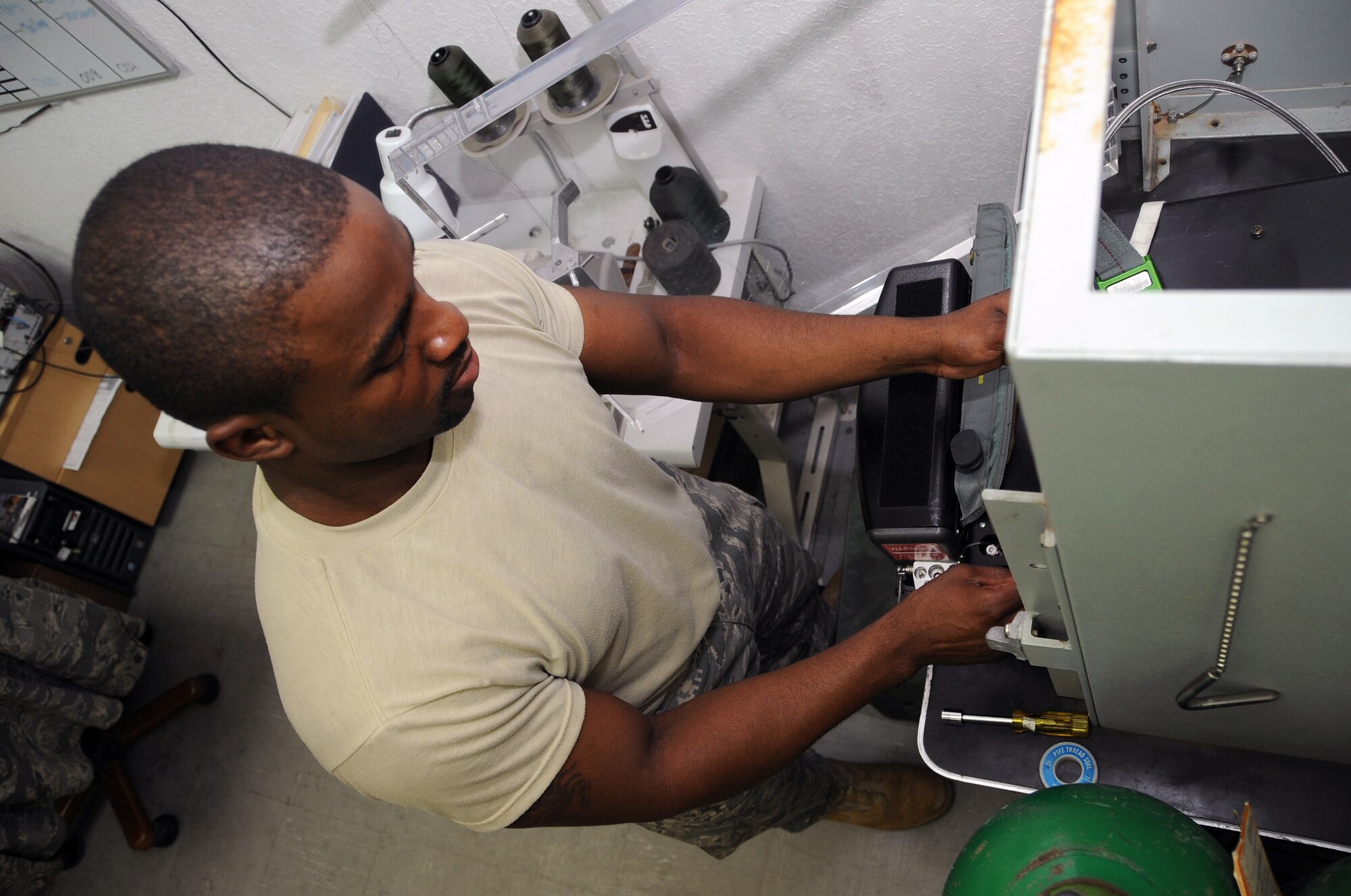 SOUTHWEST ASIA - Staff Sergeant Michael Richardson, 99th Expeditionary Reconnaissance Squadron, places a C-Kit into the charging stand July 29. Sergeant Richardson maintains life support equipment for the pilots of the 99th ERS and is deployed from Beale Air Force base, Calif. (U.S. Air Force photo Tech. Sgt. Charles Larkin Sr.)
