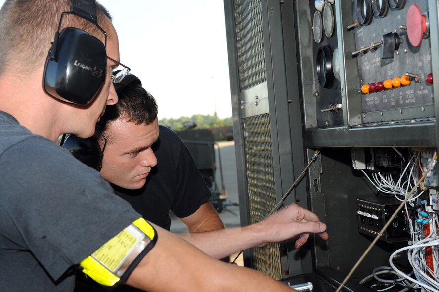 WHITEMAN AIR FORCE BASE, Mo. - Airman 1st Class Richard Temple, 509th Maintenance Squadron Aerospace Ground Equipment Mechanic, trains Airman 1st Class Joseph Fruggiero on performing maintenance on an air condition trailer. AGE mechanics perform anywhere between 40 to 60 hours of maintenance a week in support of the B-2 mission. (U.S. Air Force photo/ Senior Airman Jason Huddleston)