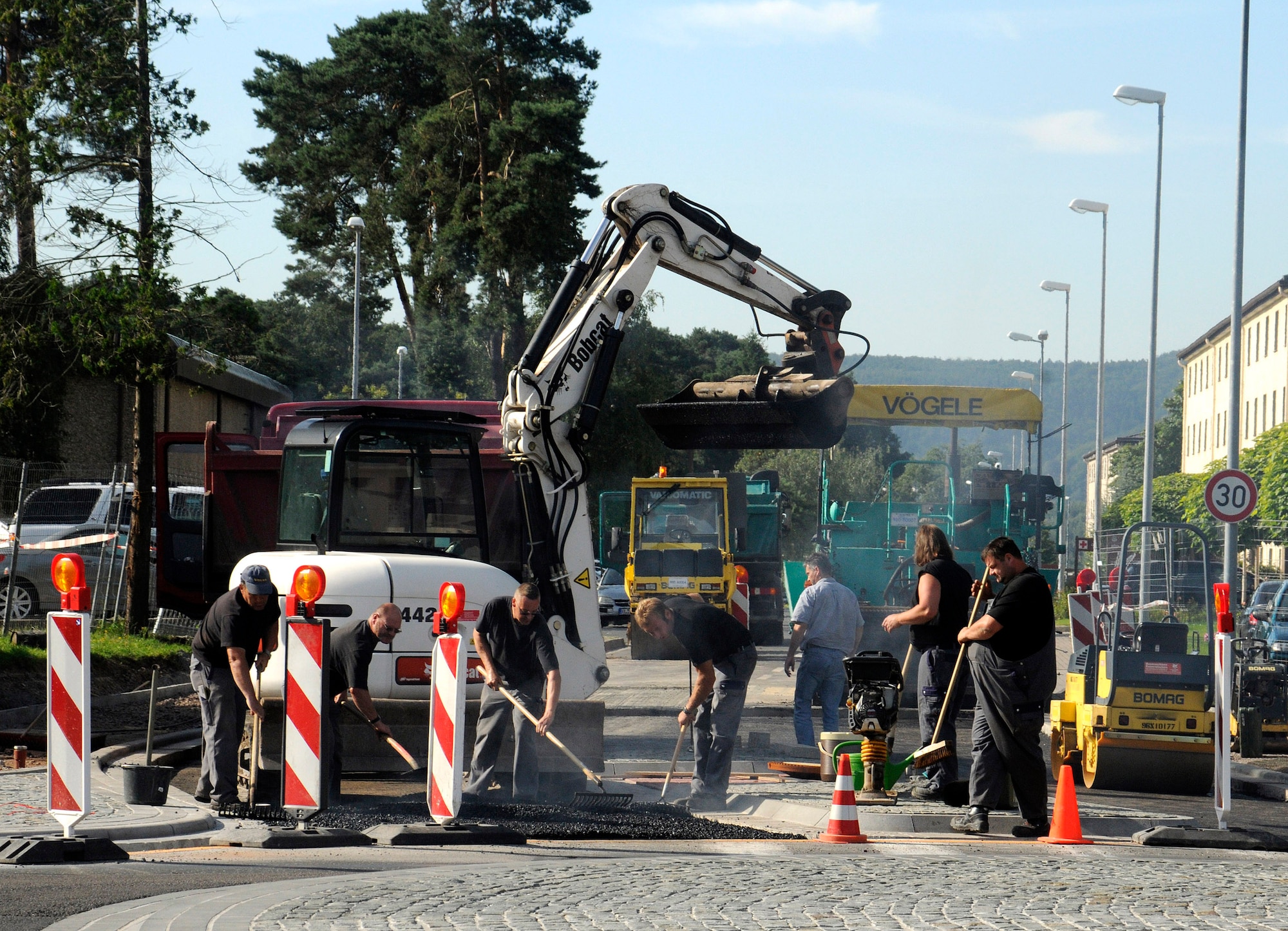 Members of the 86th Construction and Training Squadron pave the corner of Harmon Drive to complete the newly constructed roundabout circle Ramstein Air Base, Germany, July 29, 2009. The estimated completion date for the construction area is at the end of August and normal traffic patterns should resume. (U.S. Air Force photo by Tech. Sgt. Kenneth Bellard)