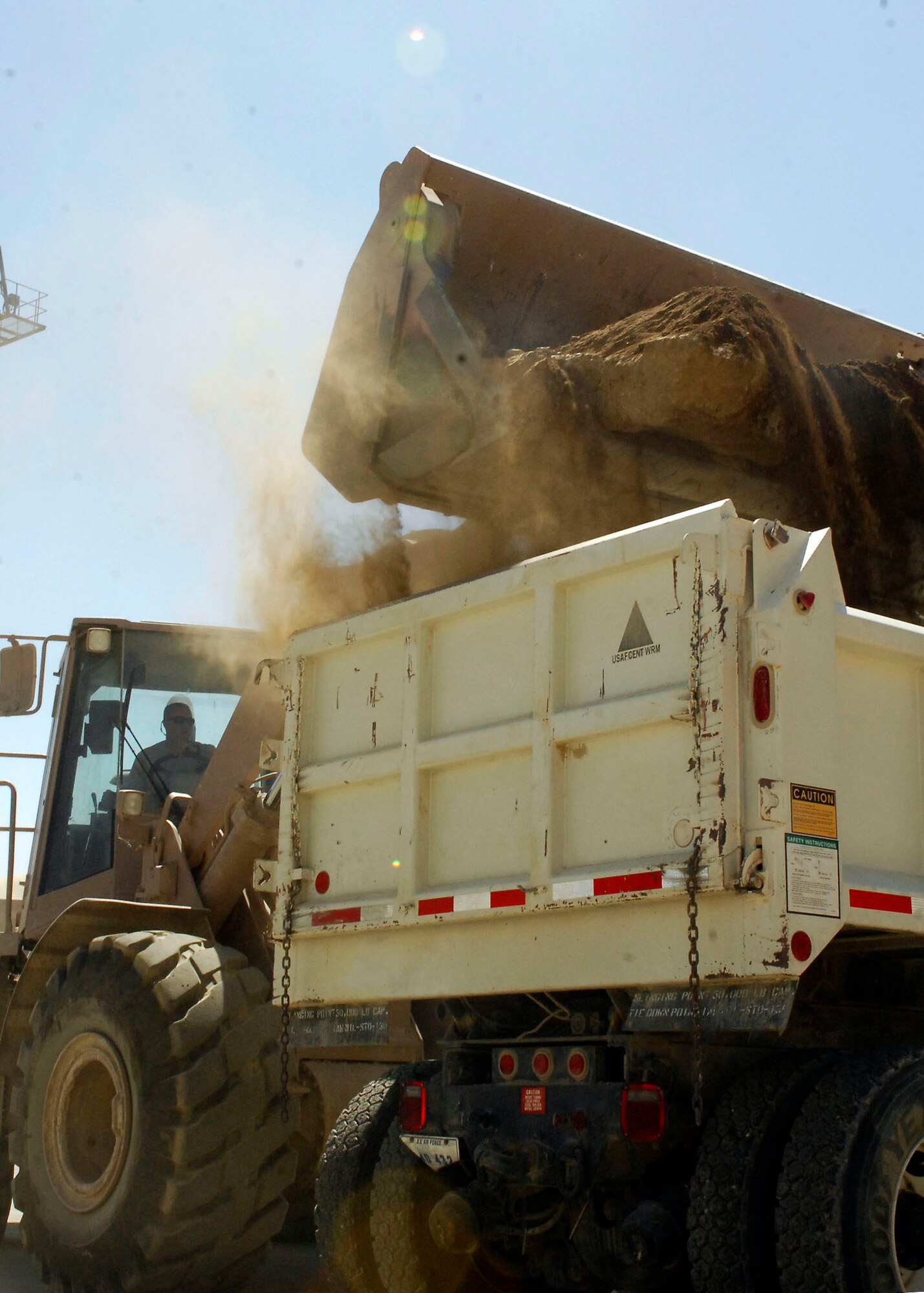 BAGRAM AIRFIELD, Afghanistan - Senior Airman Antony Vasquez, a heavy equipment operator from the 455th Expeditionary Civil Engineering Squadron, transports dirt to get taken away by a truck in order to begin laying a base to prepare for laying concrete.  Airman Vasquez is deployed from the 183rd Fighter Wing, Illinois Air National Guard and hails from Rock Island, Ill. (U.S. Air Force photo/Senior Airman Felicia Juenke)