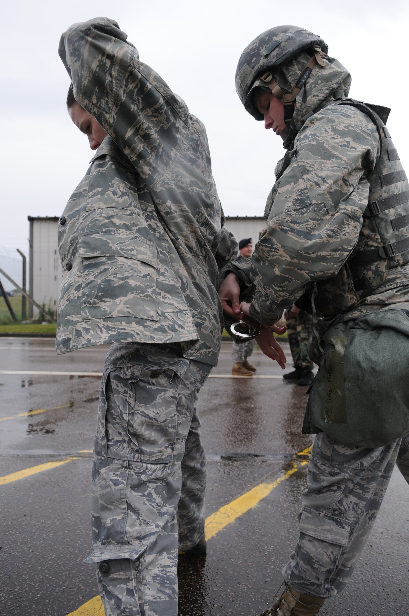 RAF MILDENHALL, England – Airman 1st Class Amber Coker, of the 100th Security Forces Squadron, restrains a “suspect” at the Base X entry control point July 21. Entry control guards discovered someone hiding in the suspects trunk during a vehicle inspection. A Phase II exercise was conducted here July 20-22 south of the flightline in preparation for an upcoming Operational Readiness Inspection. (U.S. Air Force photo by Senior Airman Thomas Trower)