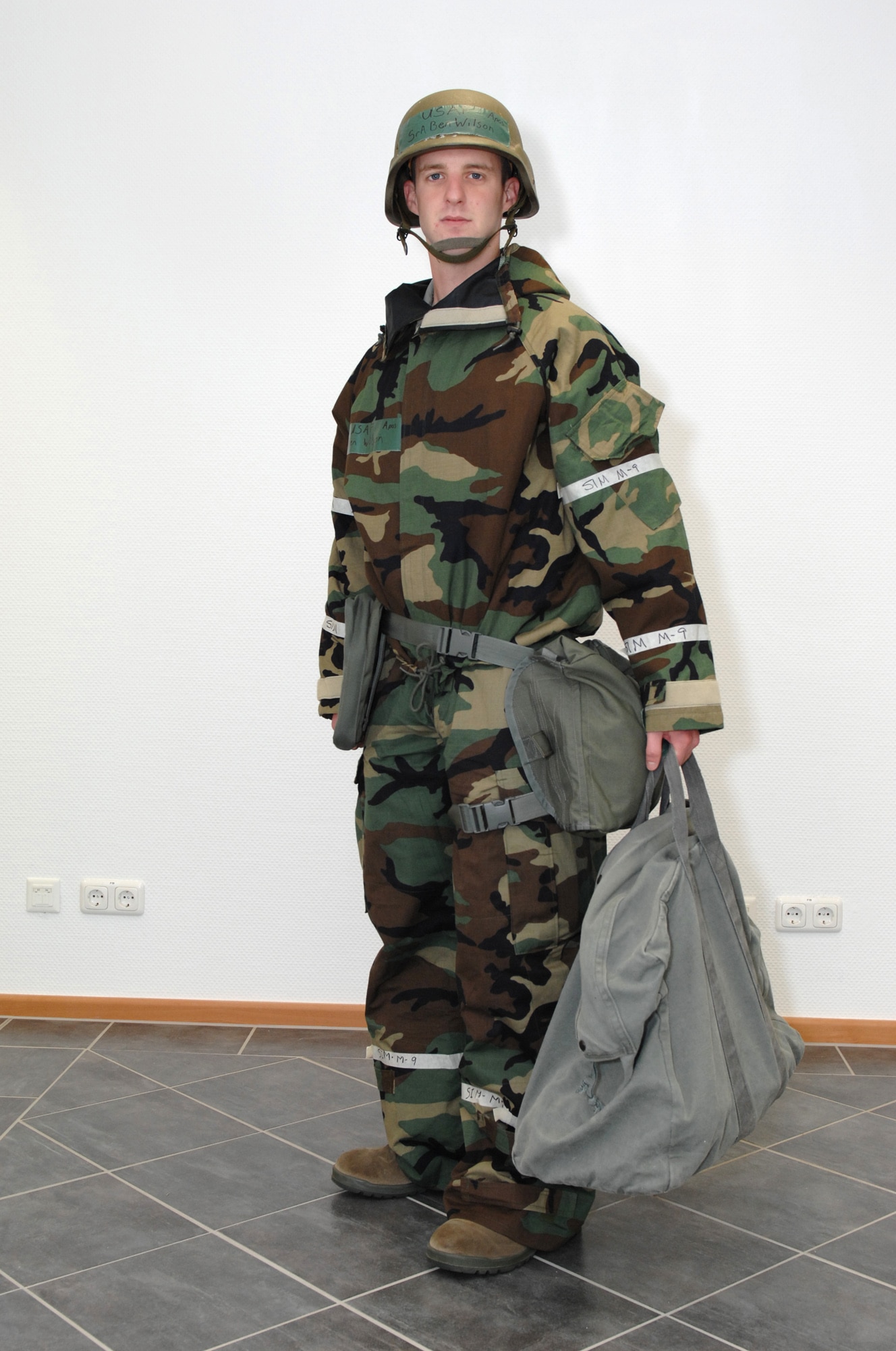 SPANGDAHLEM AIR BASE, Germany -- Senior Airman Benjamin Wilson, 52nd Fighter Wing Public Affairs Office, dresses in Mission Oriented Protective Posture 1.  People need to wear their overgarment and field gear and carry their overboots, protective mask and gloves in MOPP 1.  Aircrew will wear their overgarment and field gear and carry their overboots, protective mask, glove and overcape. (U.S. Air Force photo by Master Sgt. Bill Gomez)