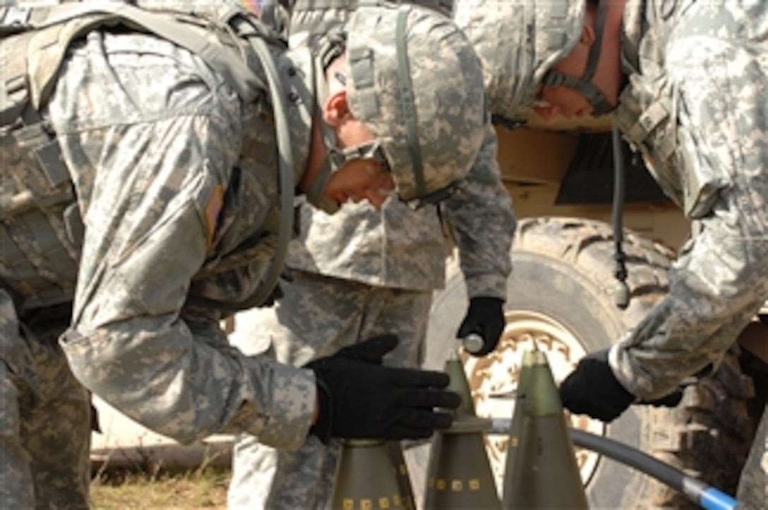 U.S. Army soldiers from Fires Squadron, 2nd Stryker Cavalry Regiment place the fuse on the artillery shells to be used in the fielding of the M777 howitzer on the Grafenwoehr Training Area, Germany, on July 24, 2009.  Fires Squadron, 2nd Stryker Cavalry Regiment is the first Army Artillery Unit to field the M777 howitzer in Europe.  