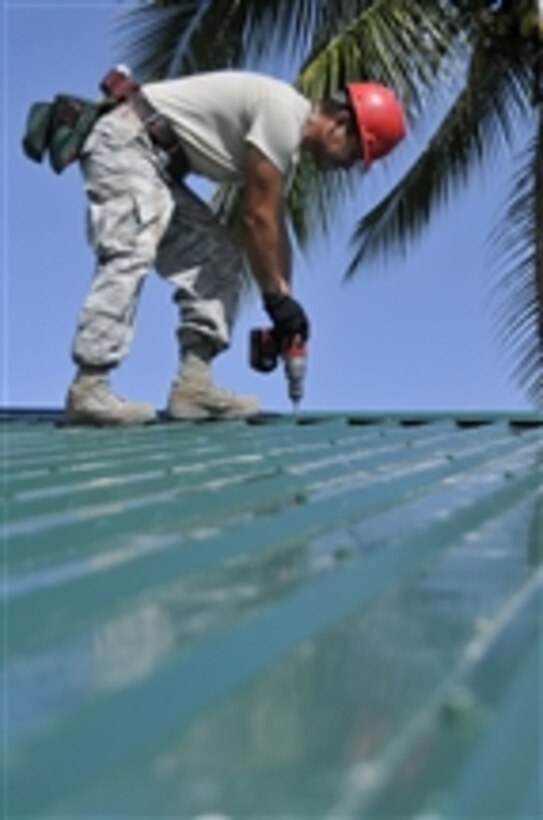 U.S. Air Force Staff Sgt. Joel Herrera-Ramos, a structural craftsman with the 555th Red Horse Squadron, from Nellis Air Force Base, Nev., installs a metal roof on the Bel-Air School in Georgetown, Guyana, on July 21, 2009.  U.S. airmen are deployed to build the school as part of New Horizons Guyana.  
