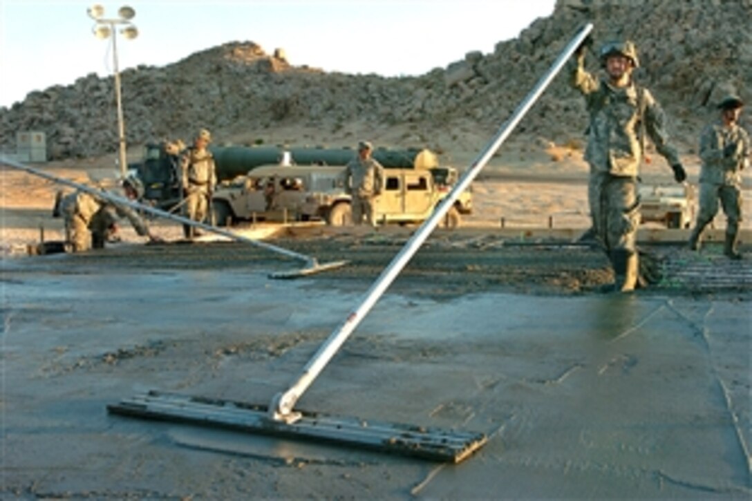 U.S. Army Spc. Gereld J. Moore carefully smoothes newly poured concrete as his unit constructs a helicopter landing pad at the National Training Center in the Mojave Desert, Fort Irwin, Calif., July 21, 2009. Moore is a combat engineer assigned to the 327th Combat Engineer Company.