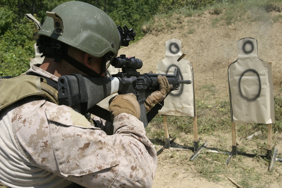 An enabler shoots a target with an M-16A4 service rifles rifle during a drill as part of an Enhanced Marksmanship Program course July 29 at Stone Bay’s Dodge City. Marines fired thousands of rounds each day in the course from M-16A2 service rifles, M4 carbine assault rifle and M9 9mm pistols.(Official USMC photo by Cpl. Richard Blumenstein)