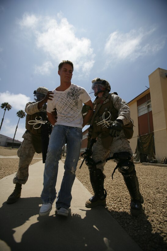 Marines with Battalion Landing Team 2/4 detain a role player during noncombatant evacuation training here July 29. The embassy reinforcement training was conducted to prepare the Marines for a deployment with the 11th Marine Expeditionary Unit later this year.
