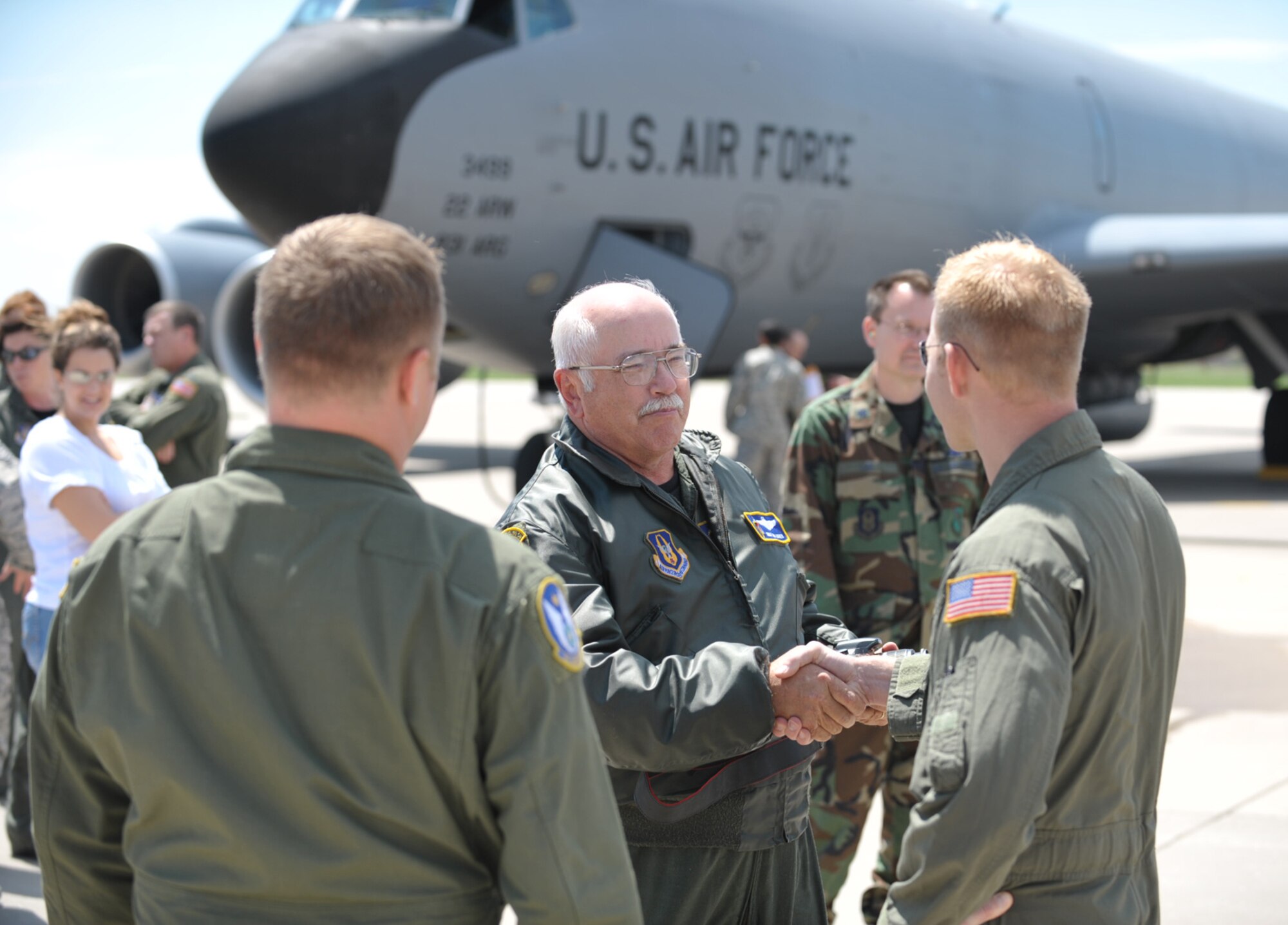 Staff Sgt. Jay Guldjord congratulates Chief Master Sgt. Don Askren (center) Thursday at McConnell Air Force Base, Kan., just after the chief completed his final flight as a boom operator for a KC-135 Stratotanker. Chief Askren, a Reservist assigned to the 18th Air Refueling Squadron, is scheduled to soon retire from the Air Force. (U.S. Air Force photo/Tech. Sgt. Jason Schaap)