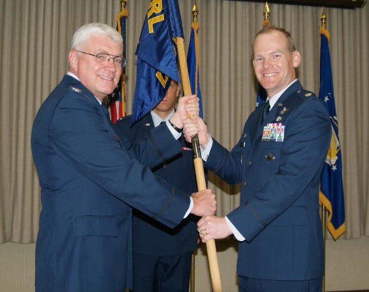 Col. Daniel P. Morin (left), Air Force Research Laboratory vice commander, passes the AFRL Detachment 3 command guidon to Lt. Col. Jeffrey Stutz. Colonel Stutz assumed command of AFRL's Hanscom Research Site during a July 27 ceremony at the Hanscom Conference Center. Colonel Morin was visiting from Headquarters AFRL at Wright-Patterson Air Force Base, Ohio.  (U.S. Air Force photo by Lee Stevens)