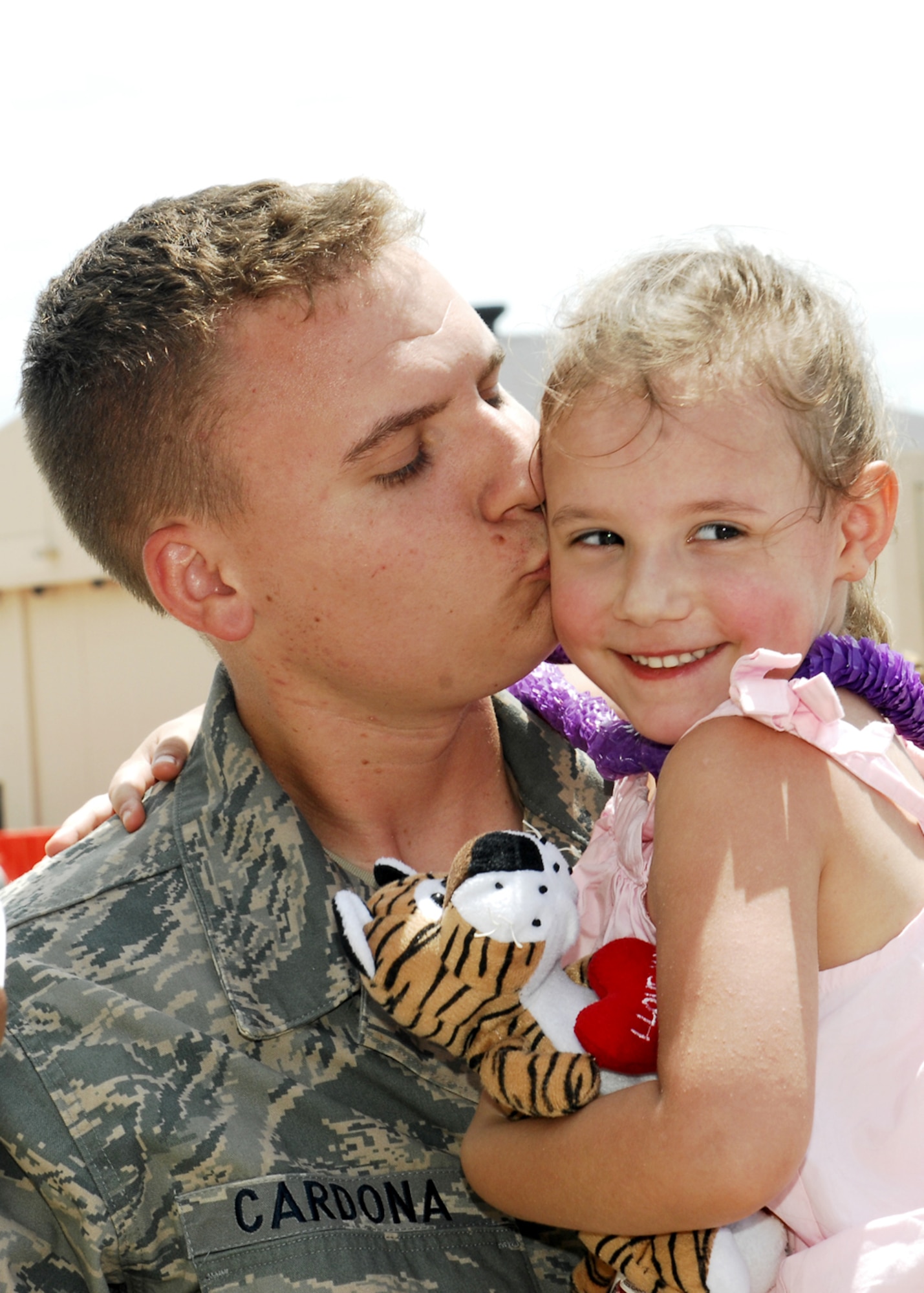 DYESS AIR FORCE BASE, Texas – Staff Sgt. Kory Cardona, 7th Aircraft Maintenance Squadron, greets his daughter with a kiss on the cheek here July 29 after returning from a six month deployment to Southwest Asia. More than 300 Airmen from the 9th Bomb Squadron, 7th Operations Support Squadron, 7th Maintenance Group and 7th Medical Group were deployed supporting Operations Iraqi and Enduring Freedom. (U.S. Air Force photo by Airman 1st Class Chelsea L. Browning)