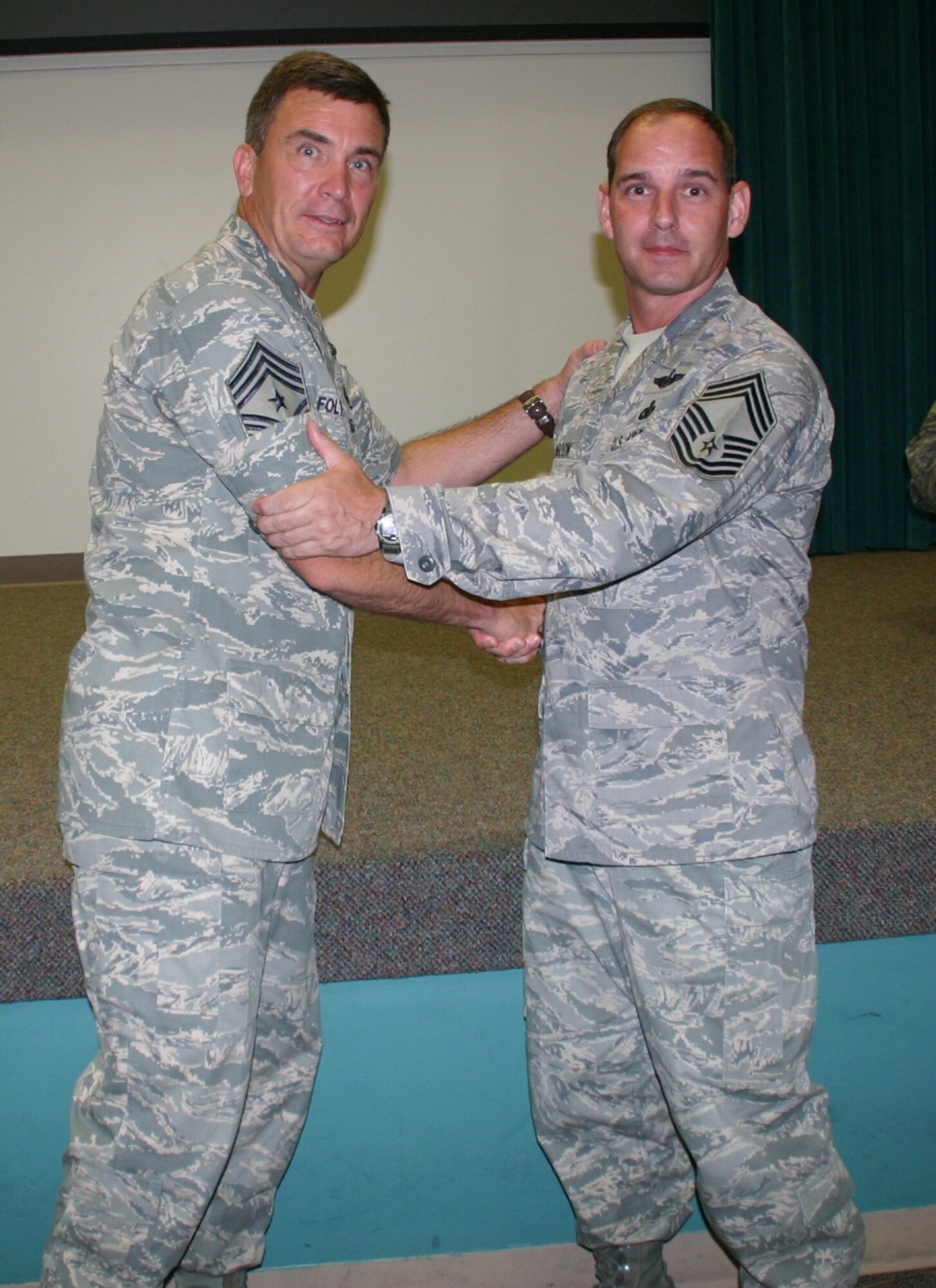 Chief Master Sgt. James Foltz, outgoing command chief, 552nd Air Control Wing, congratulates the incoming command chief, Chief Master Sgt. Scott Magoon, on becoming the wing’s new enlisted leader. Photo courtesy of 1st Lt. Kinder Blacke.