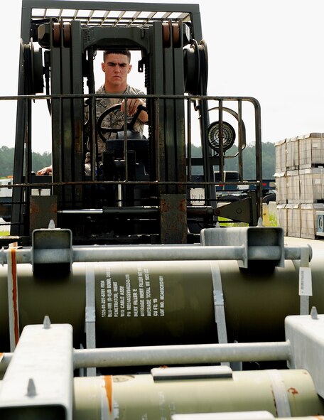 MOODY AIR FORCE BASE, Ga. -- Airman 1st Class Brian Mathis, 23rd Equipment Maintenance Squadron munitions flight stockpile surveillance crewmember, prepares to stack bomb crates to create space for storage here July 15. To take extra precaution for this procedure, Airman Mathis is spotted by two other Airmen. (U.S. Air Force photo by Airman 1st Class Joshua Green)