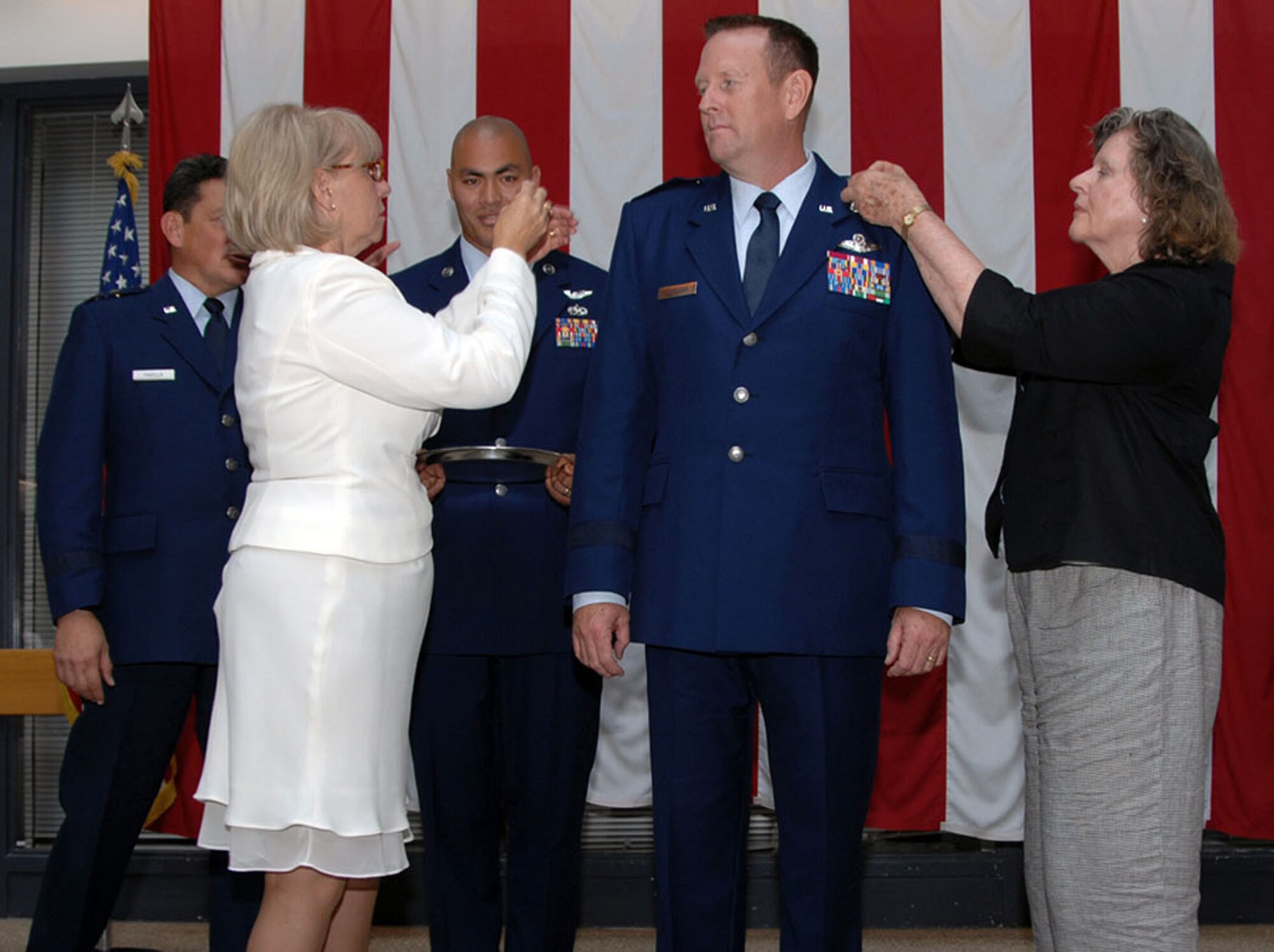 TRAVIS AIR FORCE BASE, Calif. -- Brig Gen Robert Millmann’s wife Jane, left and his mother Rosemary Millmann “pin-on” BG stars while Maj Gen Frank Padilla looks on. Gen Padilla was previously the 312th AS commander here and Gen Millmann was both the previous 79th ARS commander and the 349th AMW vice commander. (U.S. Air Force photo/Master Sgt. Robert Wade)