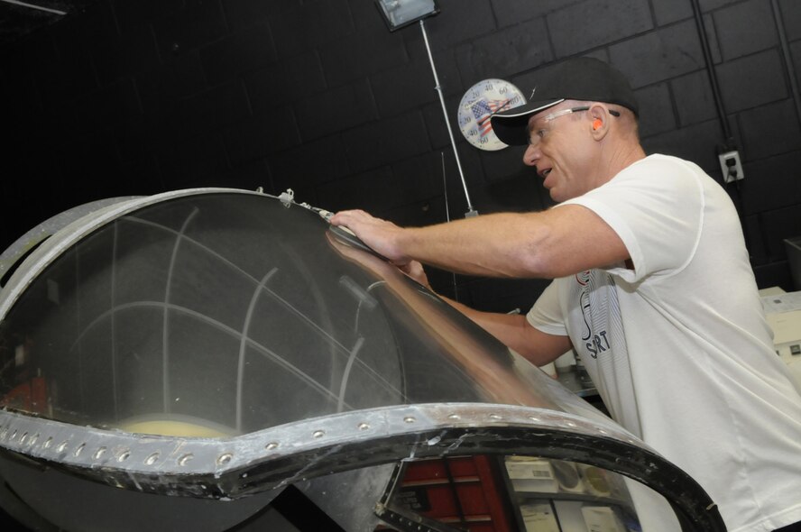 Chris Jones reconditions a wind screen for an F-15 in the canopy shop. (Air Force photo by Sue Sapp)