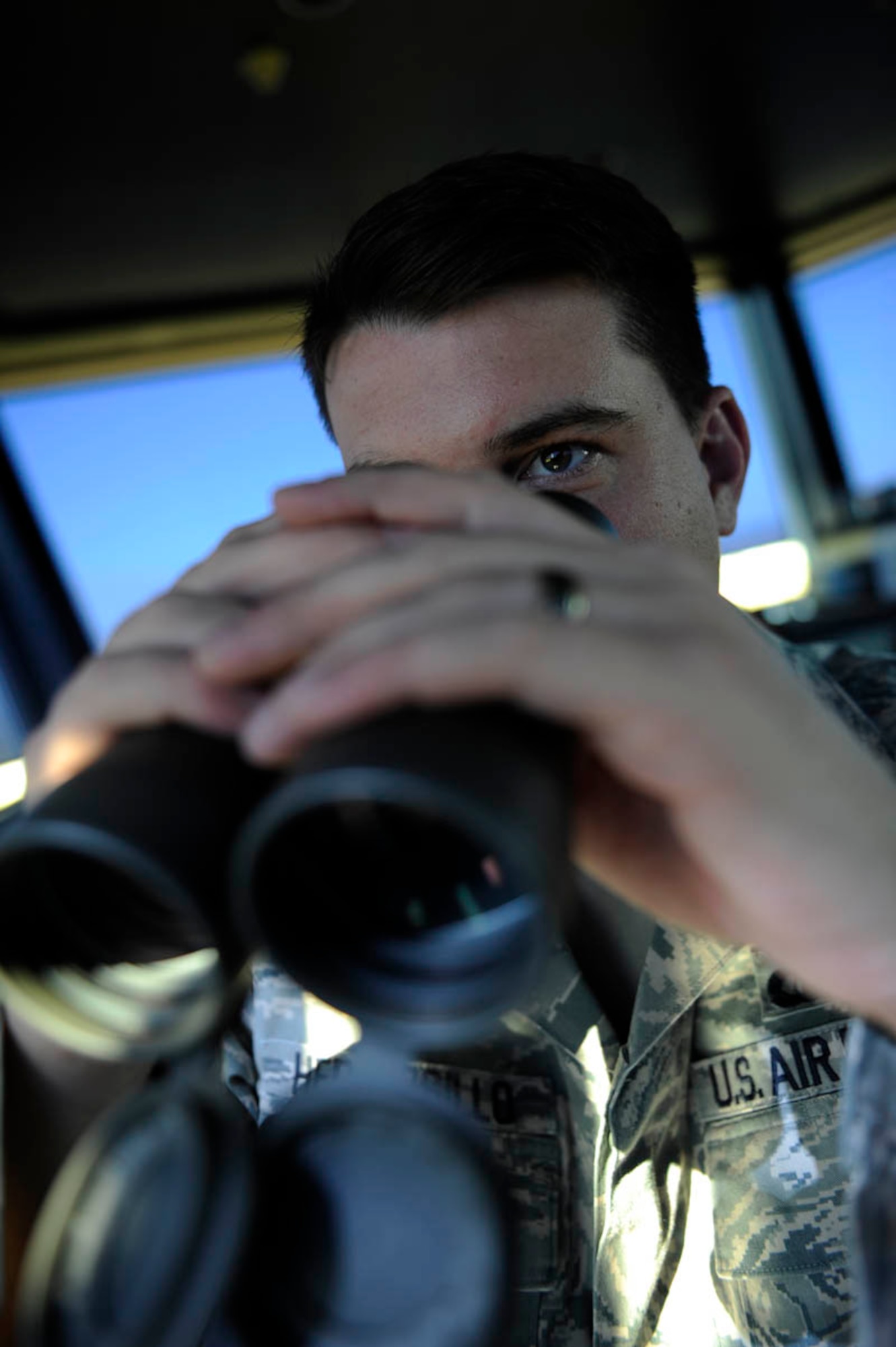 Staff Sgt. Brad Hermosillo, 28th Operations Support Squadron air traffic control specialist, watches the flight line through binoculars here July 28. Air traffic controllers ensure orderly and expeditious flow of aircraft on the airfield and in the air. (U.S. Air Force photo by Airman 1st Class Corey Hook)