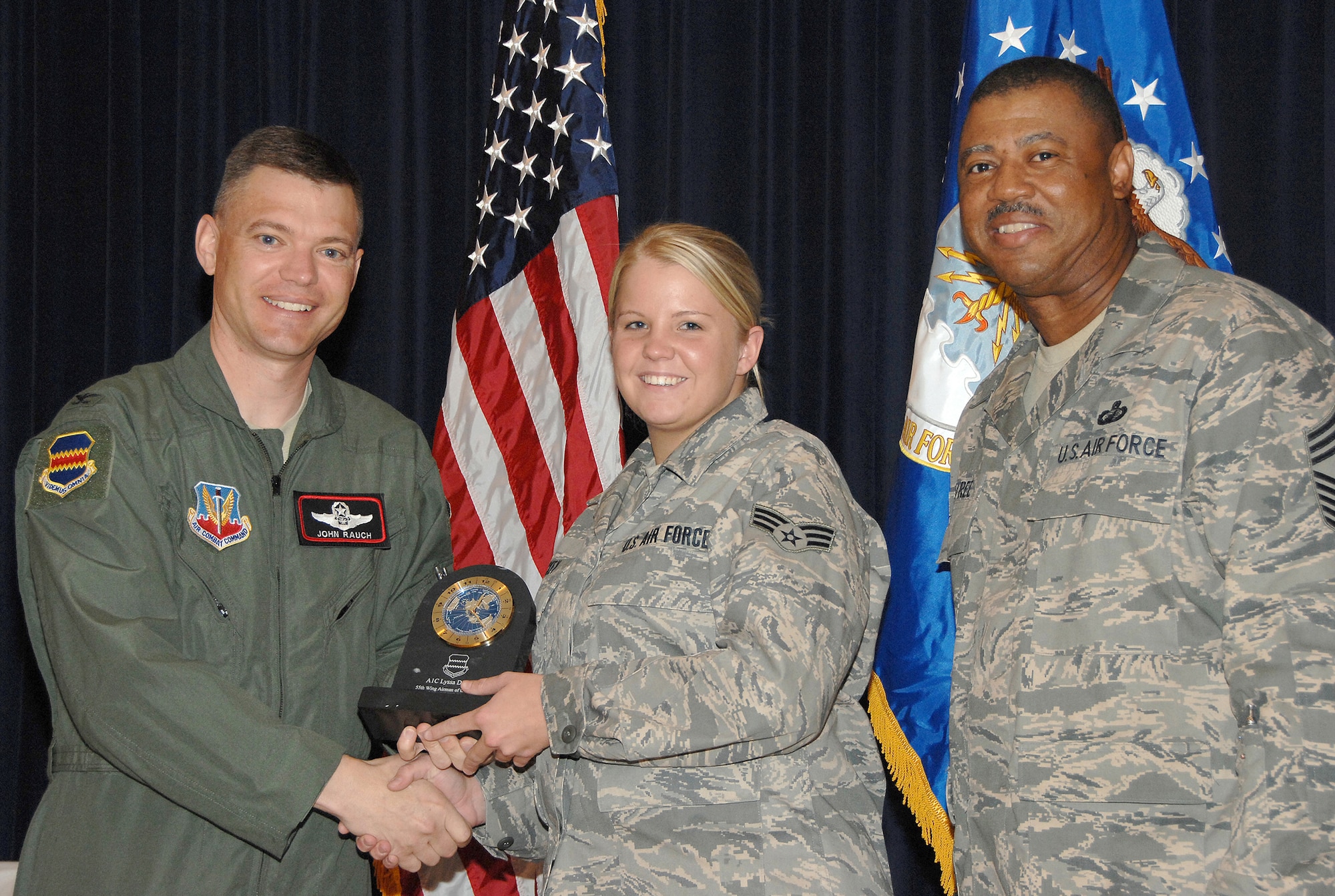 Airman 1st Class Lyssa Dickey, a telephone maintanence apprentice with the 55th Communications Squadron, receives the Airman of the Quarter Award from Colonel John T. Rauch Jr., 55th Wing vice commander,  and Chief Master Sgt. Victor Rountree, 55th Comptroller Squadron and Wing Staff superintendant, at the 55th Wing Quarterly Awards held at the Offutt Patriot Club July 23. U.S. Air Force photo by D.P. Heard