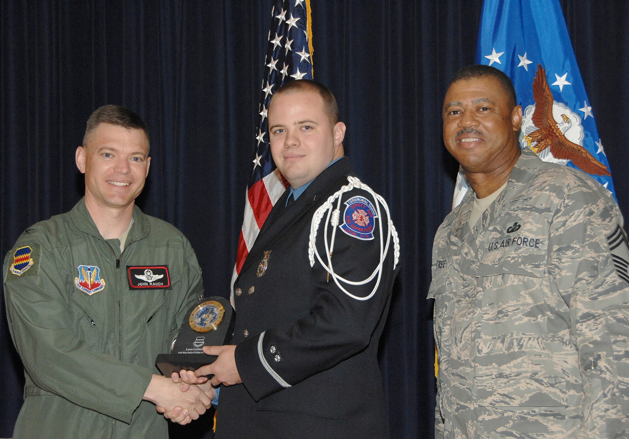 Lucas Lechtenberg, a firefighter with the 55th Civil Engineering Squadron, receives the Junior Civilian of the Quarter Award from Colonel John T. Rauch Jr., 55th Wing vice commander,  and Chief Master Sgt. Victor Rountree, 55th Comptroller Squadron and Wing Staff superintendant, at the 55th Wing Quarterly Awards held at the Offutt Patriot Club July 23. U.S. Air Force photo by D.P. Heard