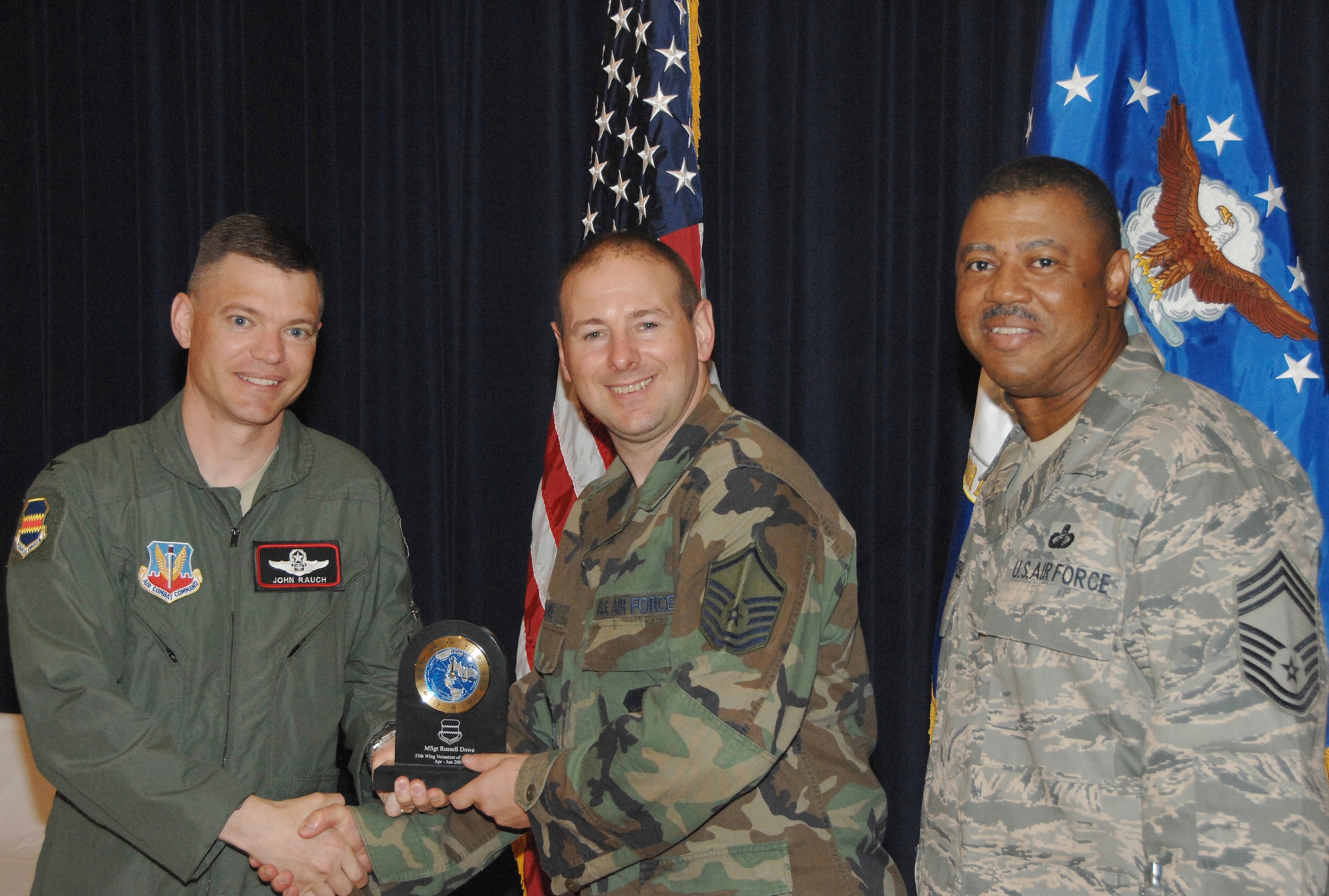 Master Sgt. Russel Dowe, a quality assurance technician with the 55th Satellite Communications Squadron, receives the Volunteer of the Quarter Award from Colonel John T. Rauch Jr., 55th Wing vice commander,  and Chief Master Sgt. Victor Rountree, 55th Comptroller Squadron and Wing Staff superintendant, at the 55th Wing Quarterly Awards held at the Offutt Patriot Club July 23. U.S. Air Force photo by D.P. Heard