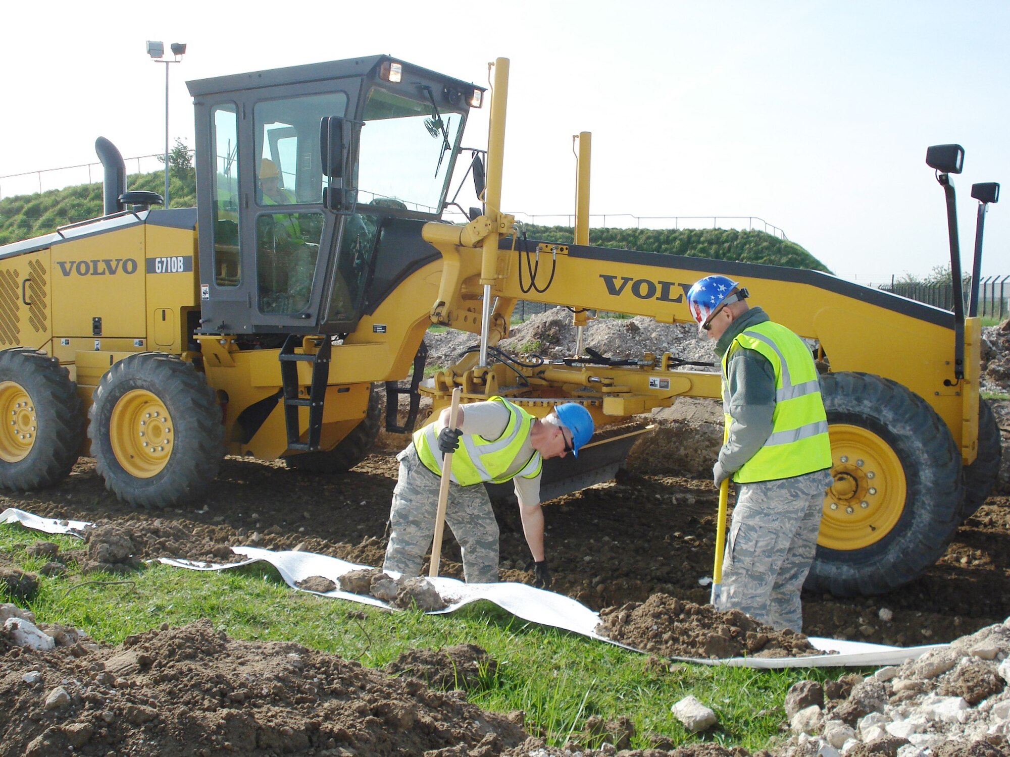 Tech. Sgt. Thomas Riggsbee, Staff Sgt. Raymond Stokes and Staff Sgt. Bobby Martin determine proper width of material during grading operations for a perimeter road in July at Royal Air Force Feltwell, England. Sergeant Riggsbee is the 86th Construction and Training Squadron's Military Construction Flight NCO in charge of structures, Sergeant Stokes is the 86th CTS/MCF NCO in charge of engineering, and Sergeant Martin is an 86th CTS/MCF pavements and equipment operator. (U.S. Air Force photo) 

