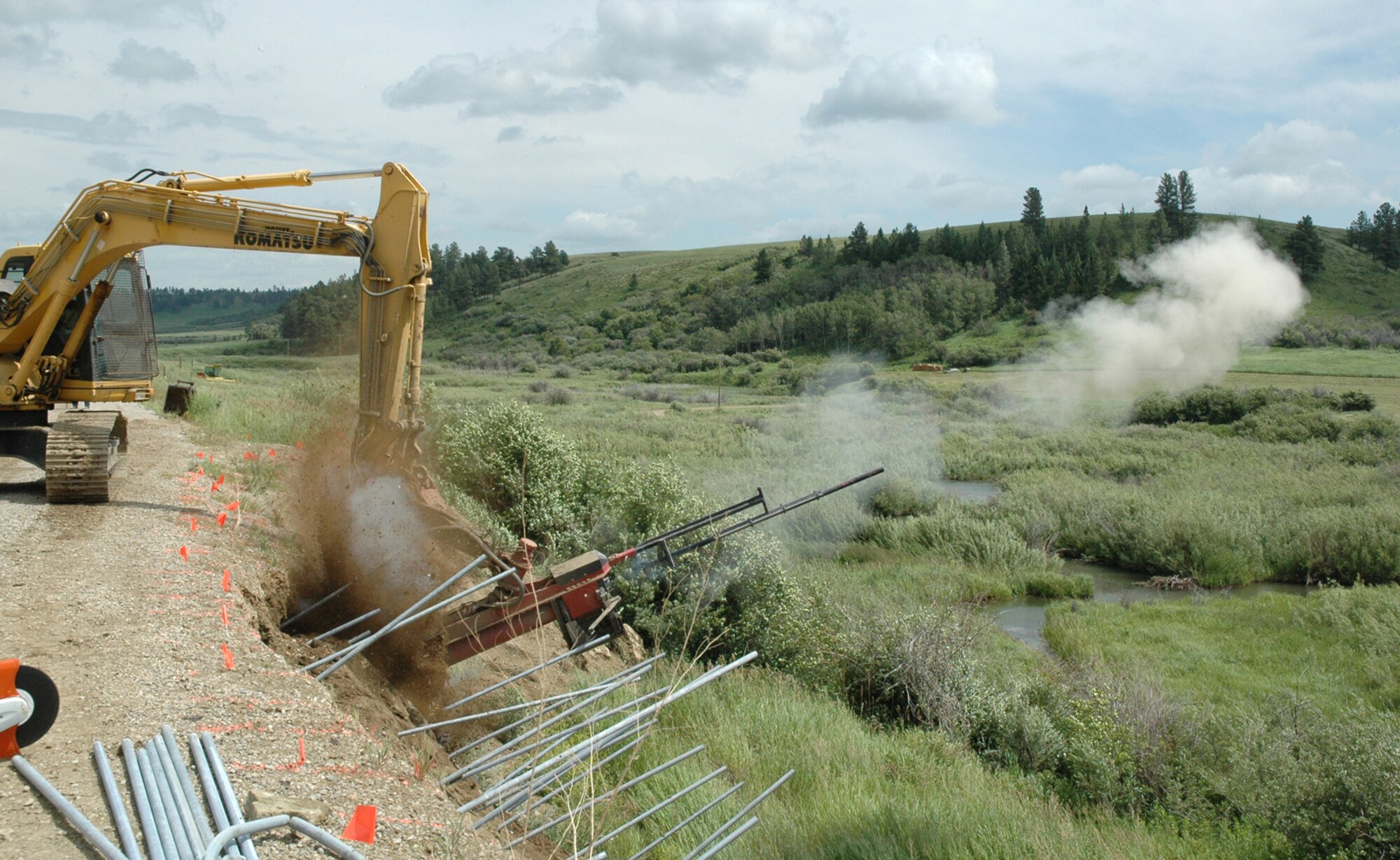 The Soil Nail Launcher fires a galvanized steel pipe into the scarp of Forest Grove Road near Lewistown, Mont. Due to increased flow of a natural underground spring and heavy rains, a land slide occurred in May, taking about 3,000 cubic yards of soil from the road. Since the repair was beyond Fergus County's capabilities and transporter erectors assigned to Malmstrom Air Force Base traverse the road, repairs were funded by the Defense Access Road Program. To complete the repair, the pipes are cut just above the surface and a wire mesh is bolted to the ends of the pipes. This wire mesh is then covered in Shockrete, a sprayable concrete used for vertical applications. (U.S. Air Force photo/Senior Airman Dillon White)