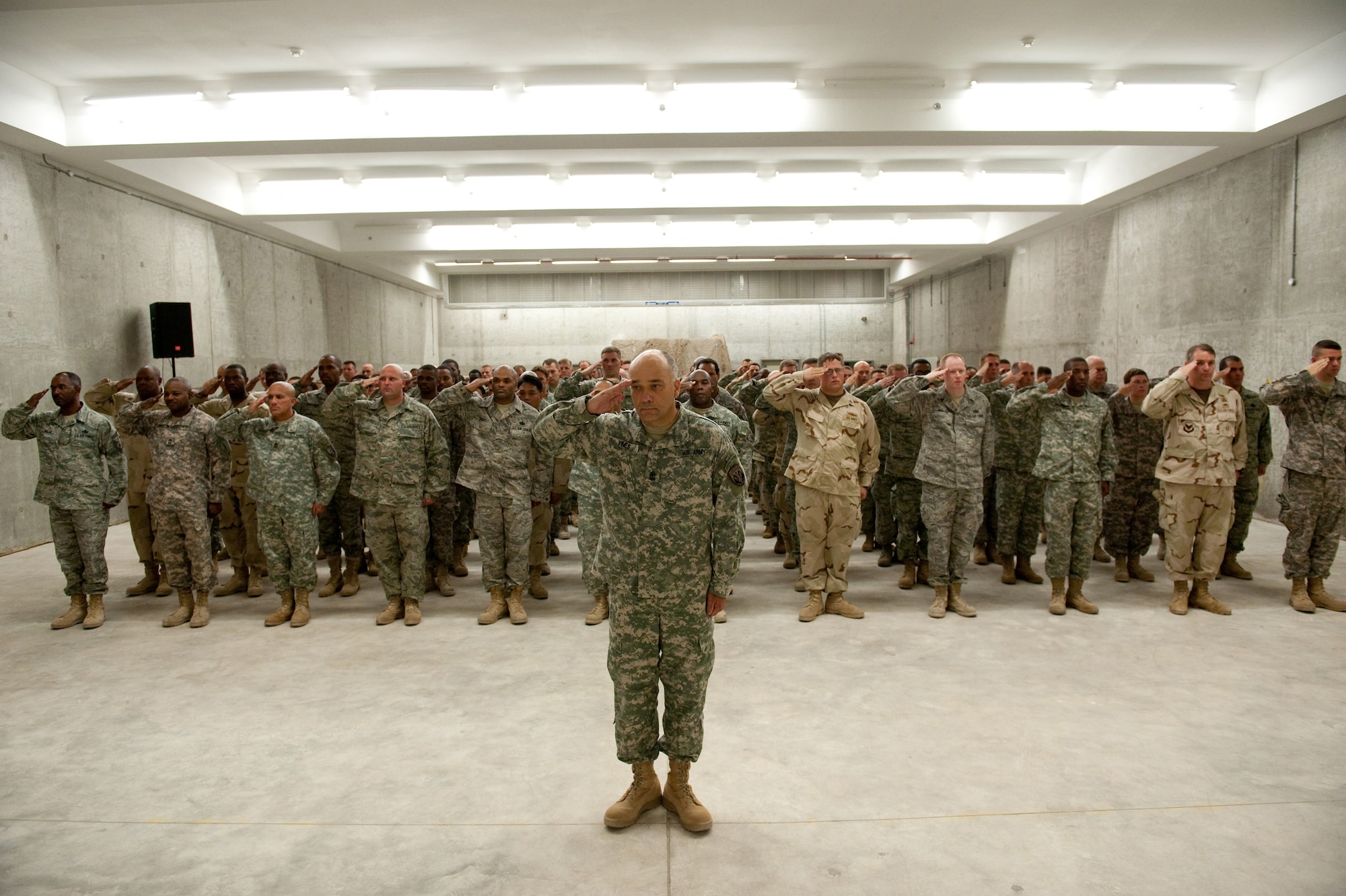 Military members of Special Operations Command Central render honors during the playing of the national anthem at a ribbon-cutting ceremony for the new SOCCENT main headquarters, July 29, in Southwest Asia.  SOCCENT plans, prepares, and directs special operations missions in support of Operations Iraqi and Enduring Freedom. (U.S. Air Force Photo by Staff Sgt. Robert Barney/Released)
