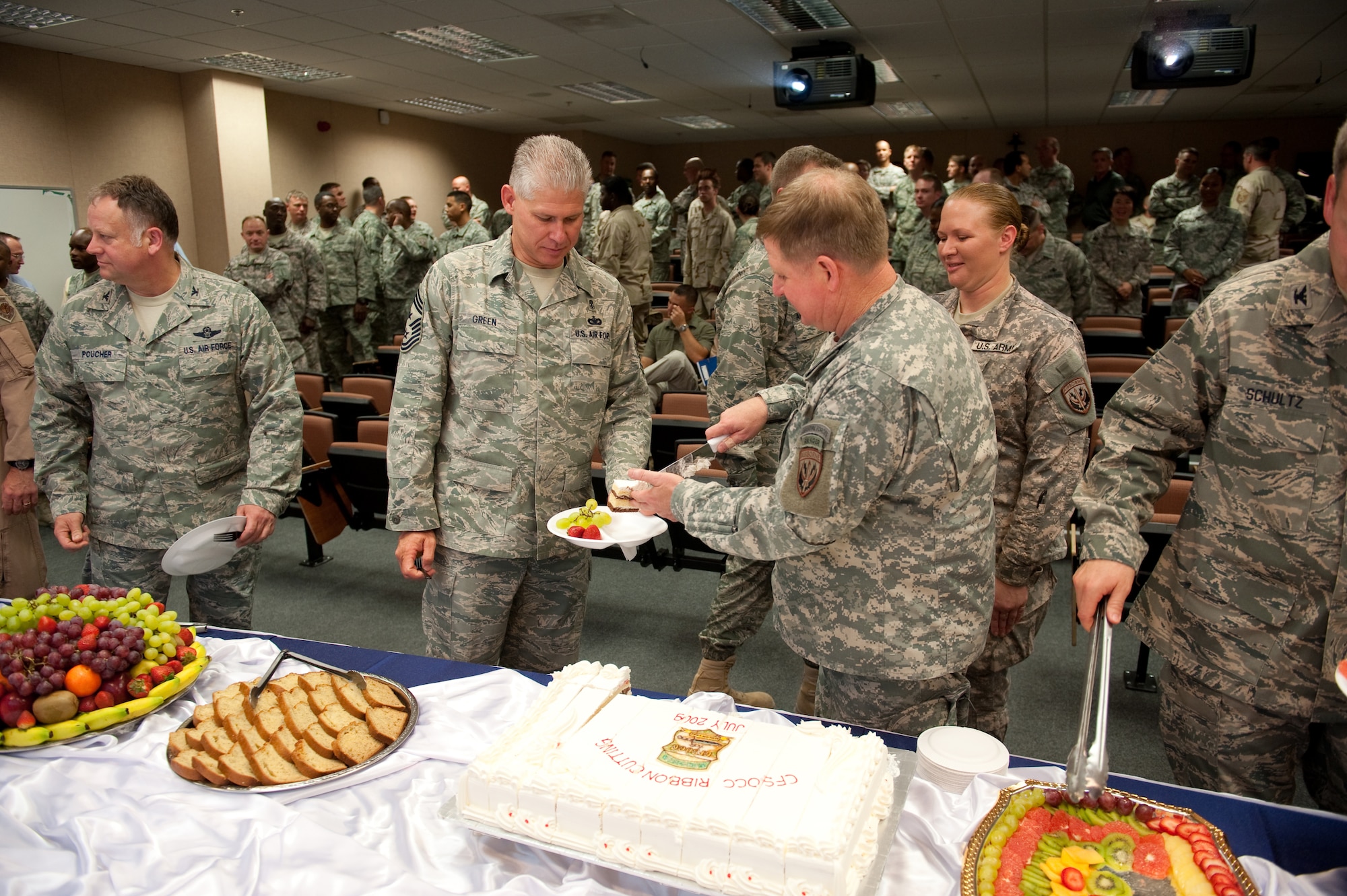 Maj. Gen. Charles Cleveland, Special Operations Command Central commander, serves cake to 379th Air Expeditionary Wing Command Chief Master Sgt. David Green and other distinguished guests at the ribbon-cutting ceremony for the new SOCCENT main headquarters, July 29, in Southwest Asia.  SOCCENT plans, prepares, and directs special operations missions in support of Operations Iraqi and Enduring Freedom. (U.S. Air Force Photo by Staff Sgt. Robert Barney)