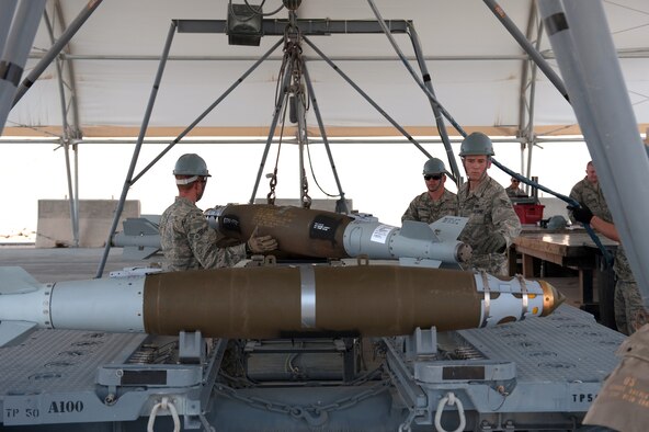 Left to right, Senior Airman James Deason, Staff Sgt. Matthew Hutzenbiler, and Airman 1st Class Larry Maloney, 379th Expeditionary Maintenance Squadron, secure GBU-38s for transportation to a ready line in preparation for loading an aircraft, July 20, in Southwest Asia.  The 379 EMXS munitions flight provides aircraft with both offensive and defensive devices to support various air tasking orders. Airmen Deason and Maloney are deployed from Dyess Air Force Base, Texas, and Sergeant Hutzenbiler is deployed from Ellsworth, S.D. All servicemembers are deployed in support of Operations Iraqi and Enduring Freedom. (U.S. Air Force Photo/Staff Sgt. Robert Barney)