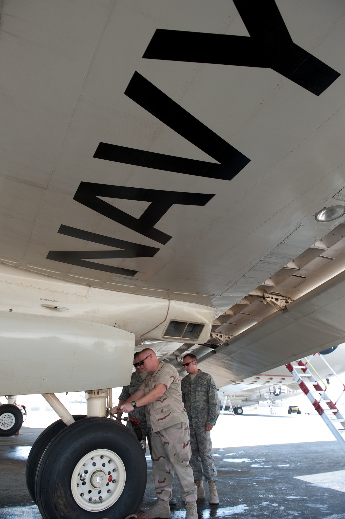 Petty Officer 2nd Class Justin Strong, Navy Patrol Squadron 10 aviation structural mechanic, replaces a hydraulic line on a P-3C Orion, July 27, in Southwest Asia. Petty Officer Strong teamed with Master Sgt. Michael Ormerod and Staff Sgt. Andrew Teigen, 379th Expeditionary Maintenance Squadron aircraft structural maintainers, on this short-notice repair and their joint effort ensured the aircraft's mission readiness. The P-3C provides an over-watch of U.S. and Coalition Forces, gathering intelligence to assist them on the ground and on the sea. All servicemembers are deployed in support of Operations Iraqi and Enduring Freedom. (U.S. Air Force Photo/Staff Sgt. Robert Barney)