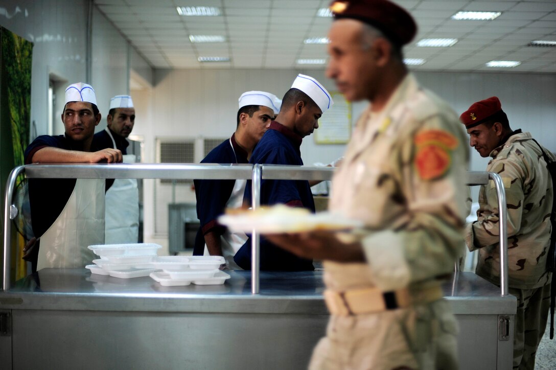 Iraqi soldiers eat lunch at their dining facility July 12 at Camp Taji, Iraq. This dining facility is run exclusively by the Iraqi army with some assistance from an American Airman assigned to the Logistics Military Adviser Team. (U.S. Air Force photo/Staff Sgt. Michael B. Keller) 
