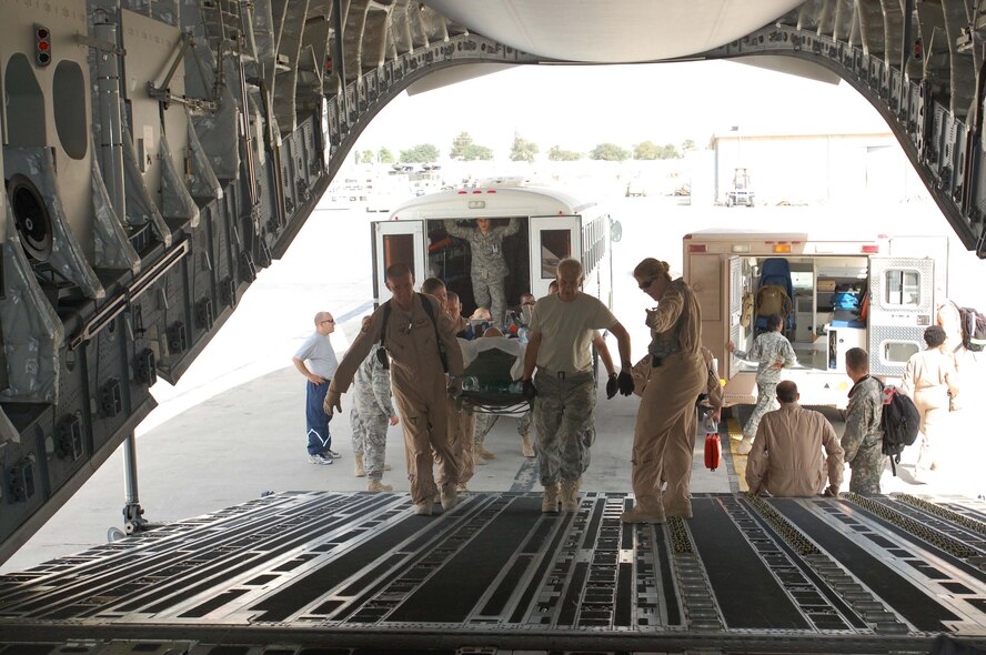 Capt. Christine Jones, 934th Aeromedical Evacuation Squadron, directs patient loading aboard a C-17 in Southwest Asia July 4.  The efforts of Captain Jones and her crewmembers saved the lives of many critically ill and injured patients. (Air Force Photo/Maj. Shannon Mann)
